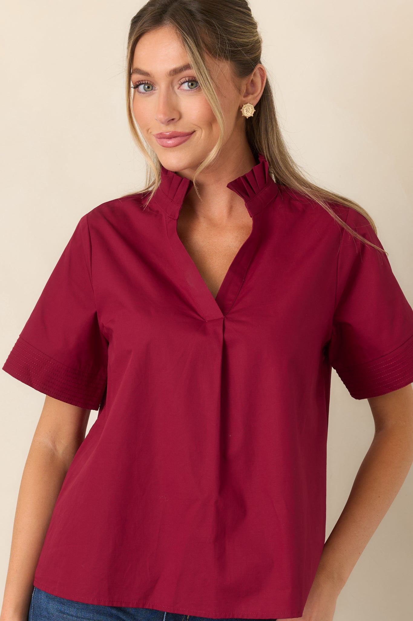 Close view of the cotton top highlighting the softly pleated ruffle collar and relaxed split neckline.