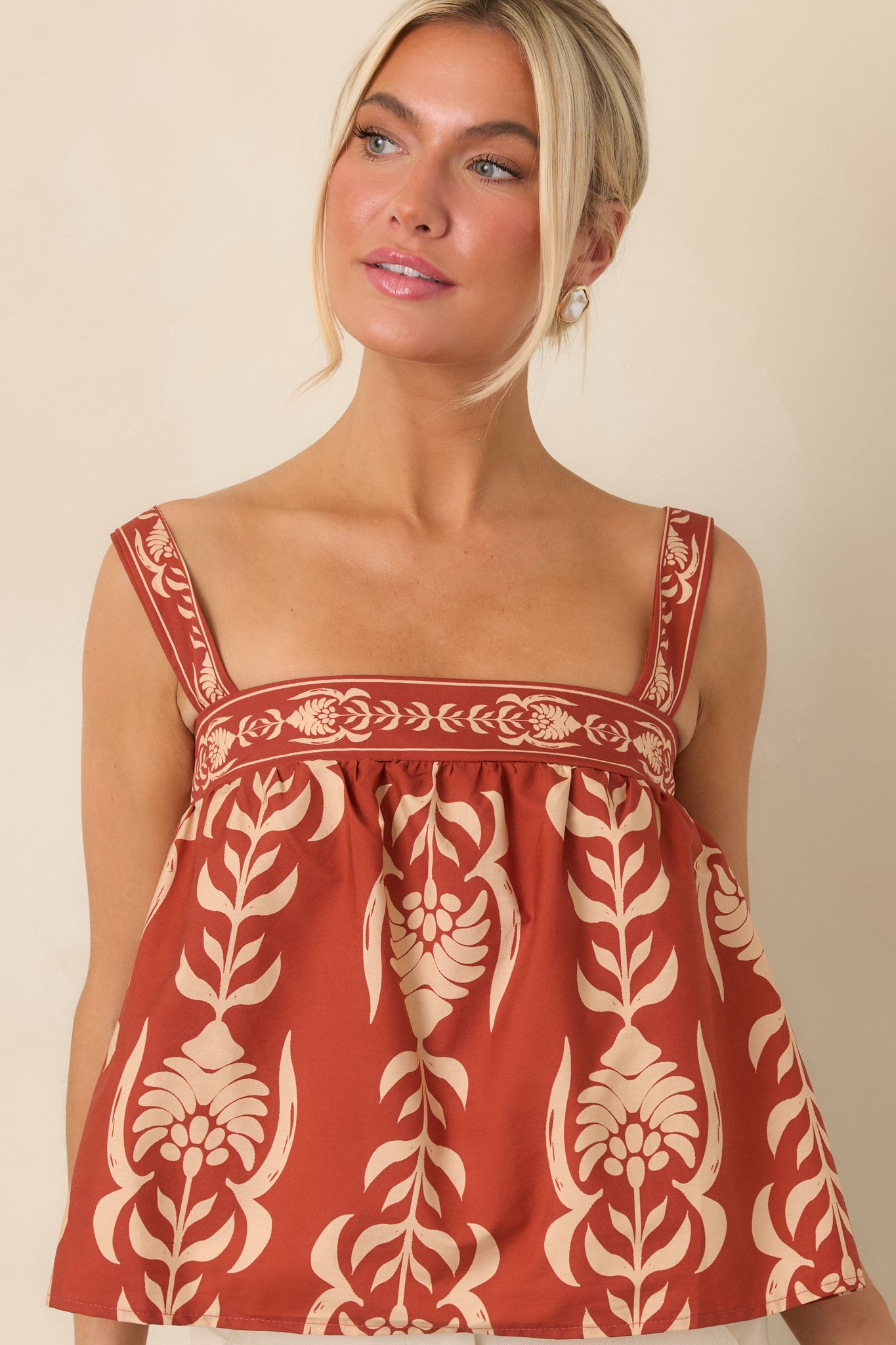 Detailed view of the wide shoulder straps and square neckline framing the relaxed cotton top.