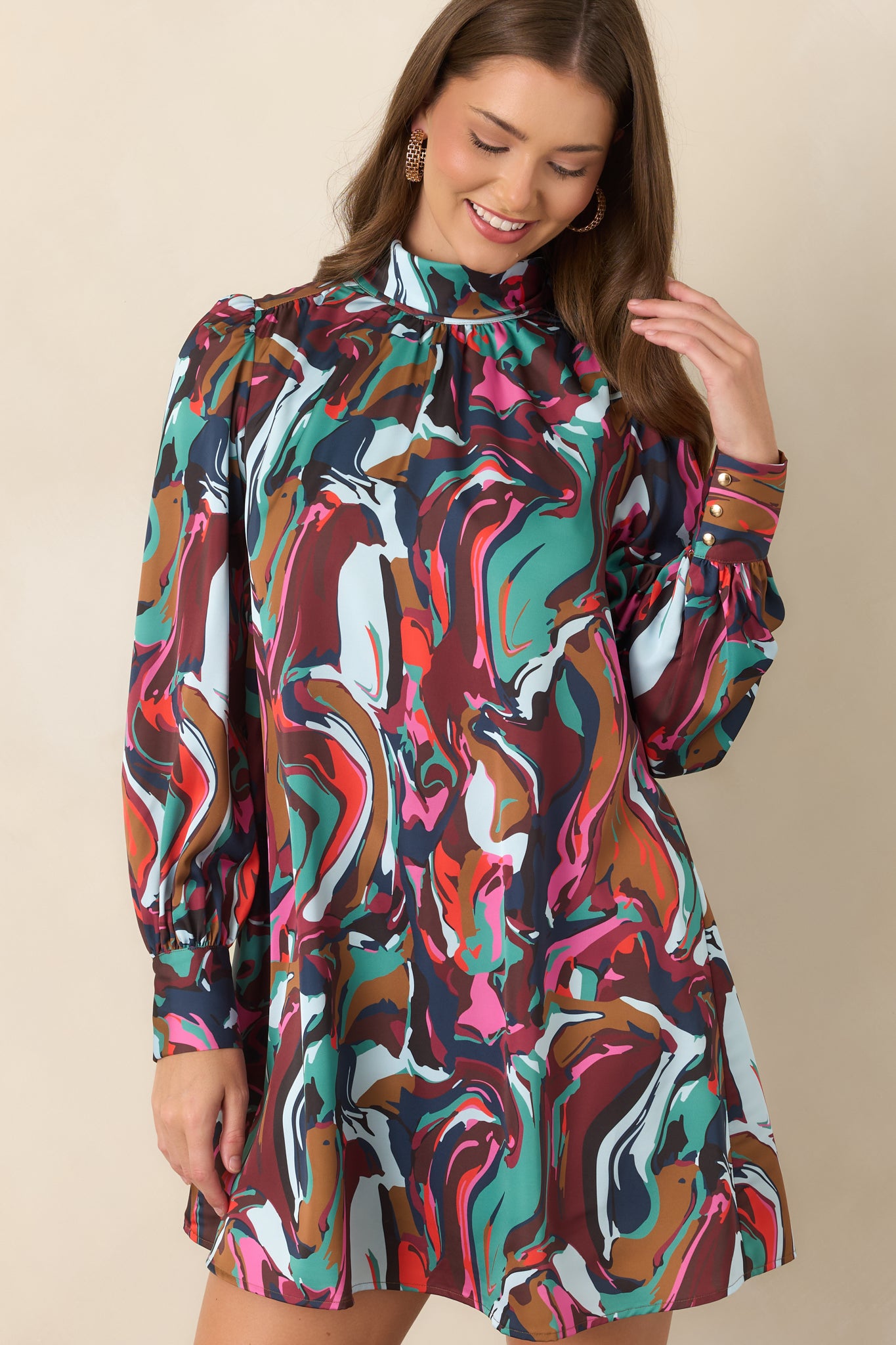 Close view of the abstract-print mini dress highlighting the high cowl neckline, delicate tie detail, and gathered shoulder construction.
