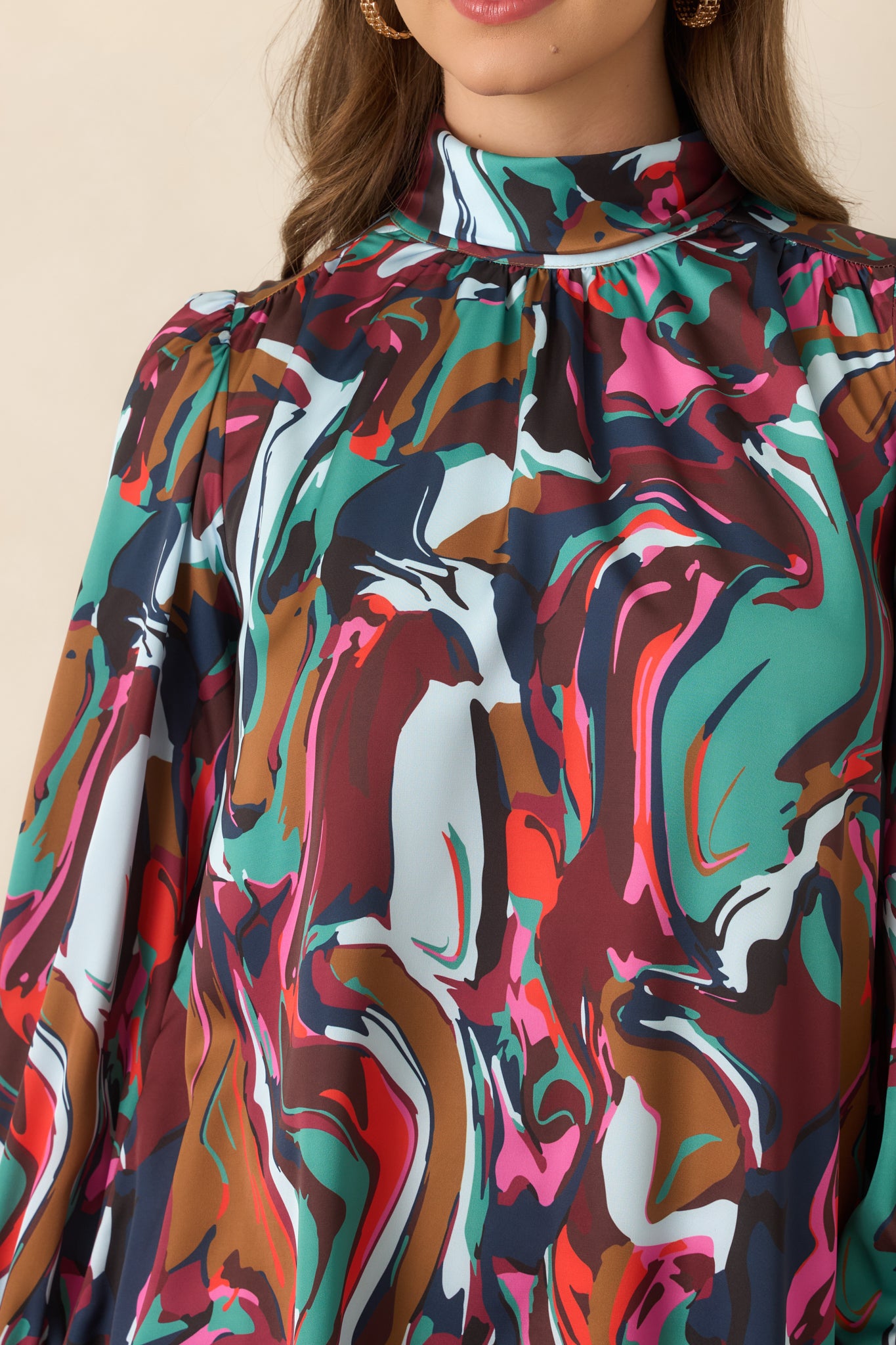 Close-up detail of the mini dress highlighting the high cowl neckline, gathered shoulder, tie accent, and softly lustrous crepe texture.