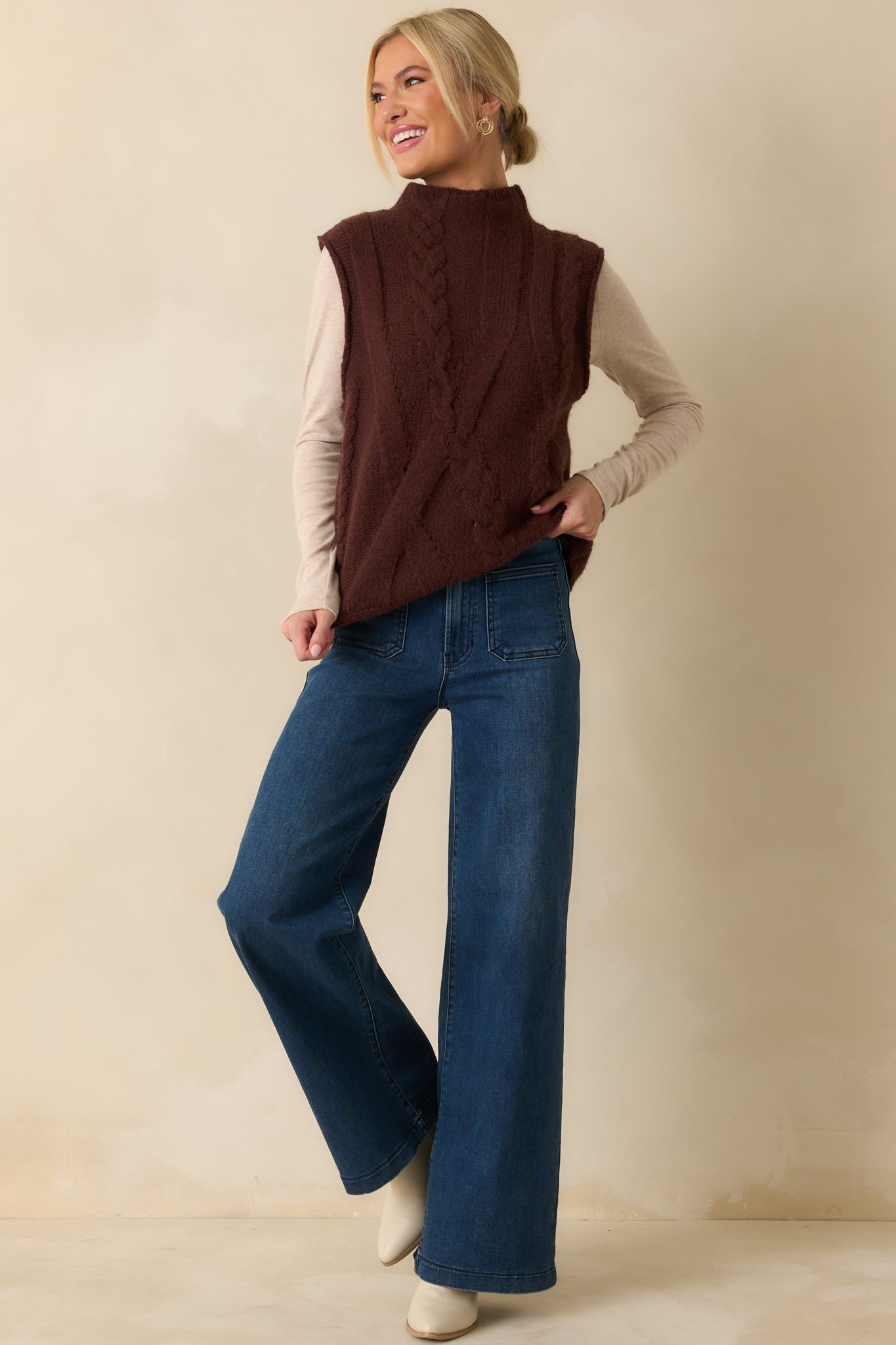 Cozy brown vest highlighting its sleeveless silhouette and ribbed trim along the neckline and hem