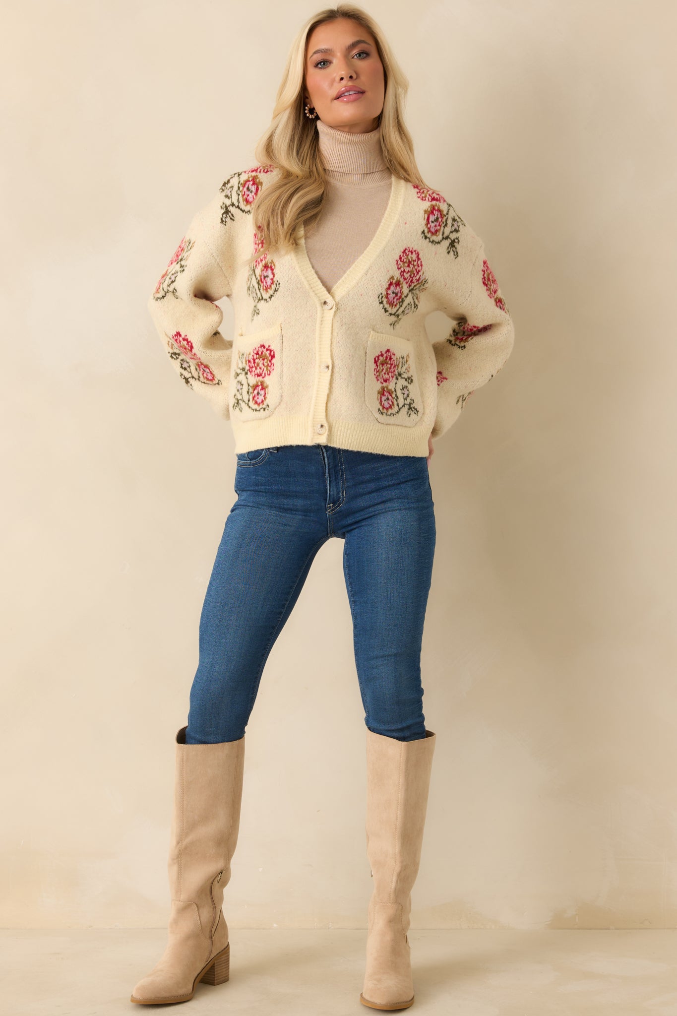 Cozy ivory cardigan with ribbed trim and decorative pocket florals adding a gentle, classic touch.