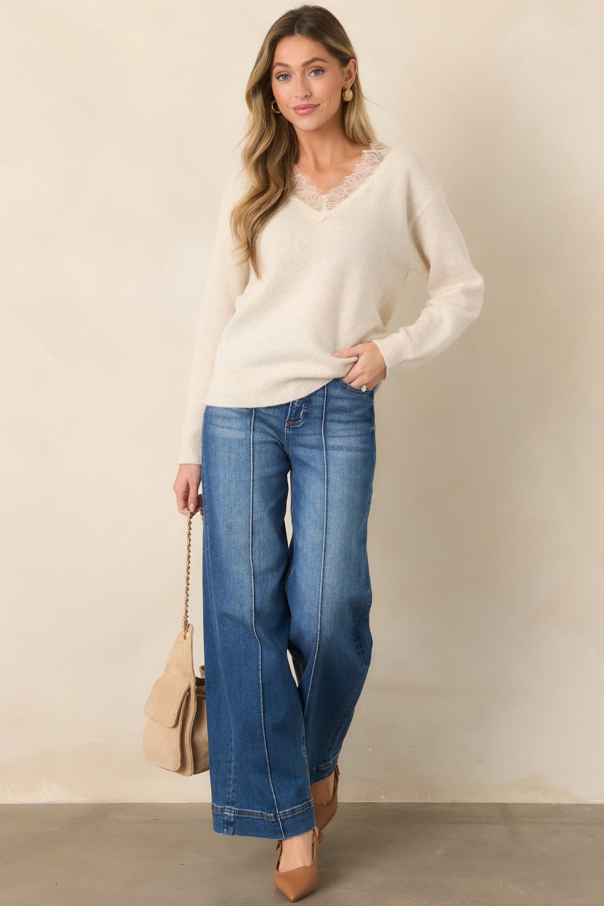 Cozy ivory sweater showcasing a soft knit and romantic lace neckline.