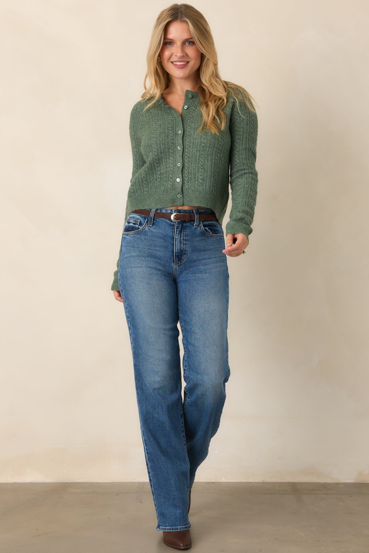 Cozy knit cardigan featuring a clean round neckline, tonal buttons, long sleeves, ribbed trim, and a streamlined slightly cropped shape.