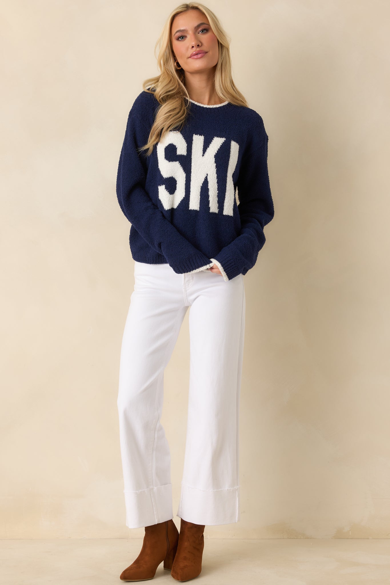 Cozy navy sweater displaying long sleeves and crisp white block lettering.