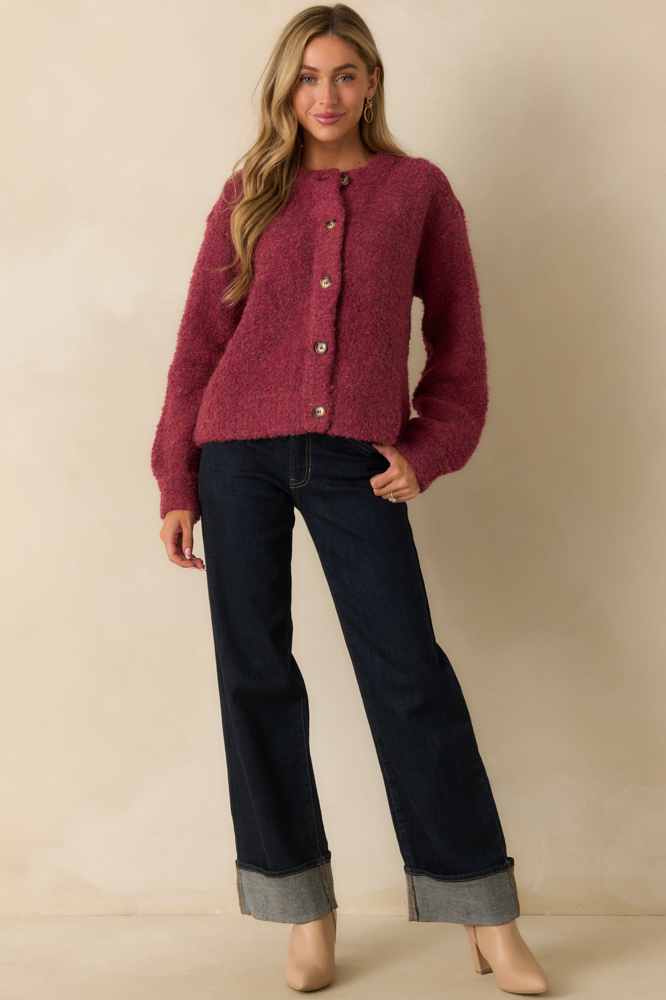 Cranberry boucle knit cardigan styled buttoned up, showing its soft texture and relaxed silhouette.