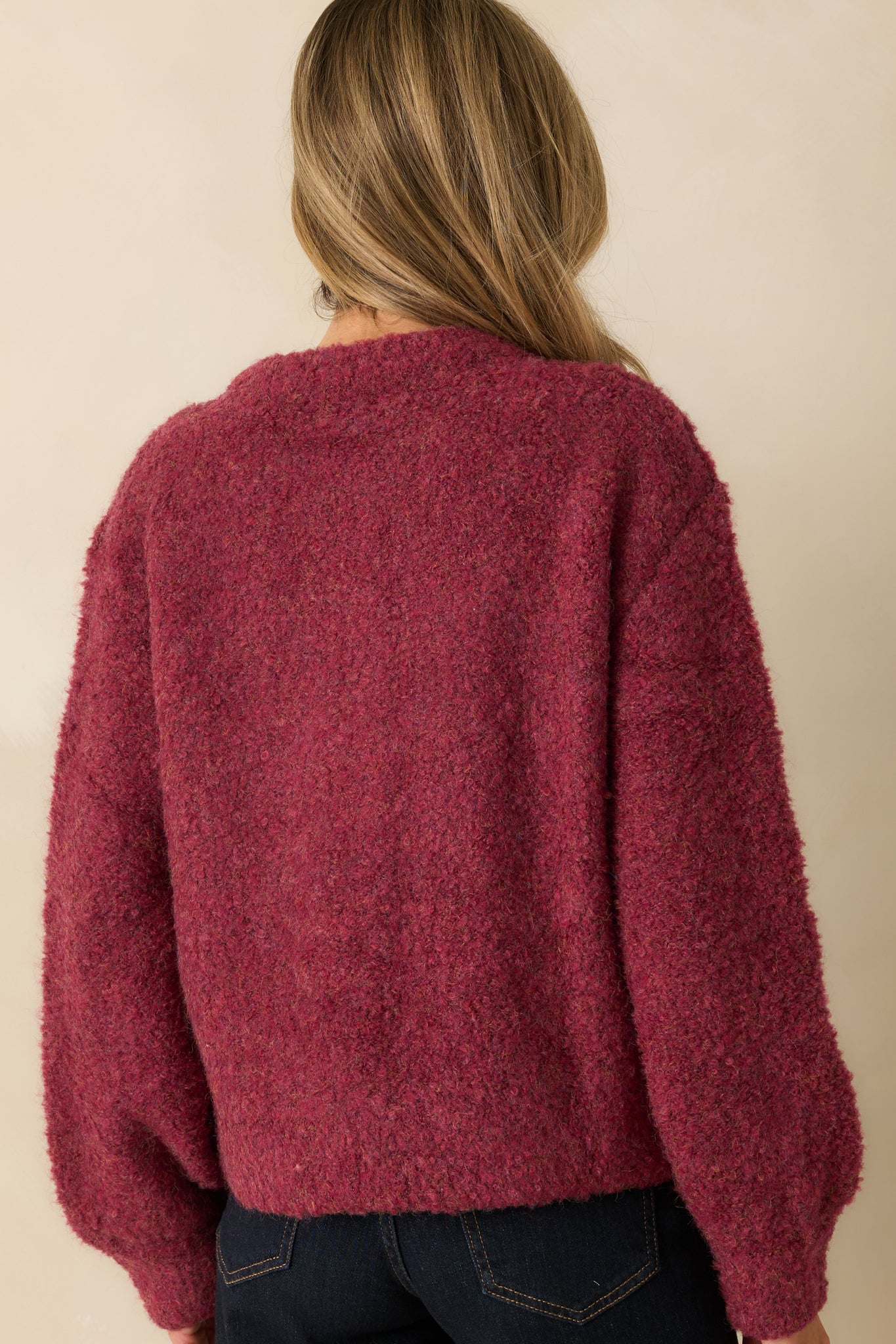 Rear view of the cranberry cardigan showing its relaxed silhouette and uniform boucle knit texture.