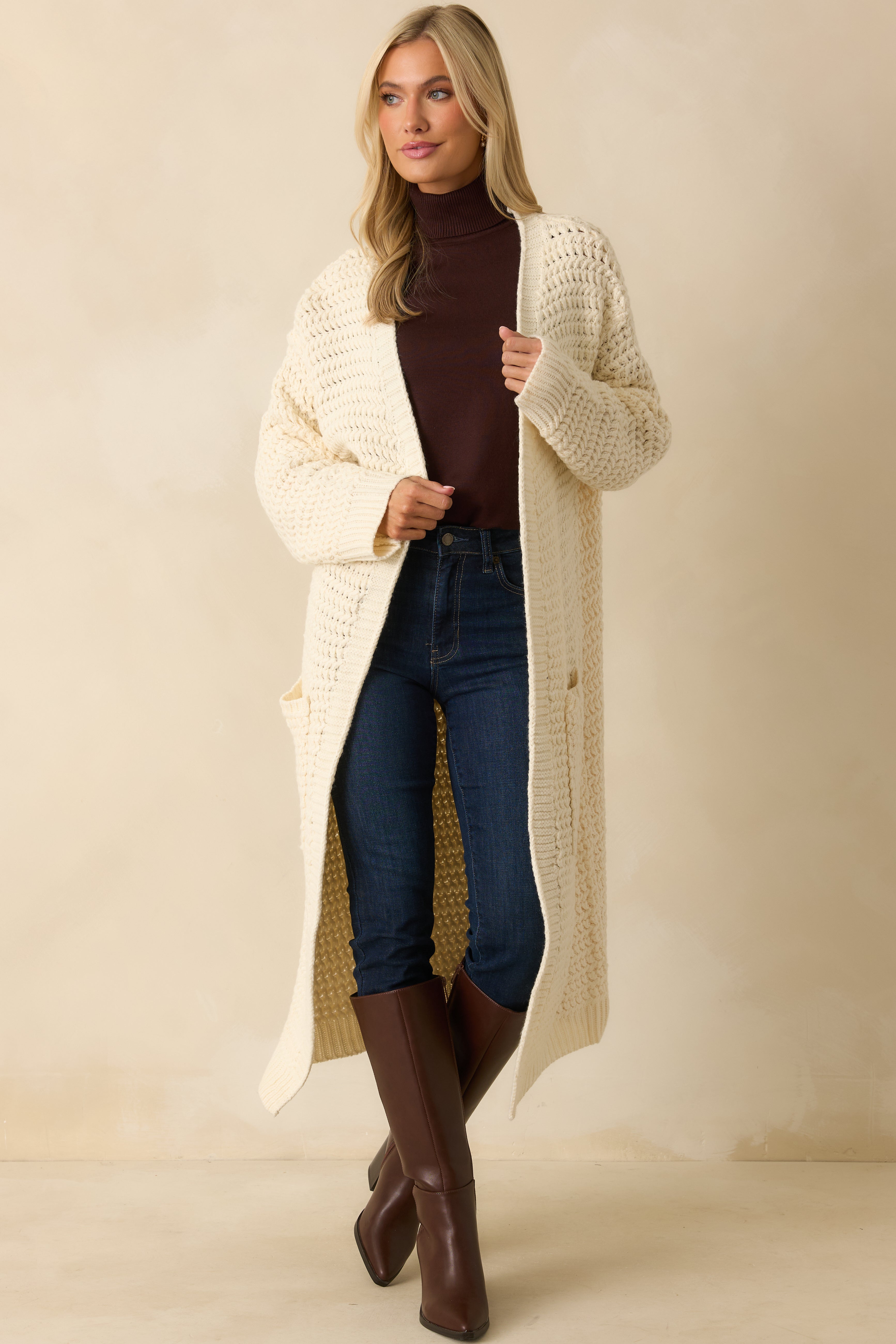 Front view of the cream duster cardigan emphasizing the open front and chunky knit detailing.