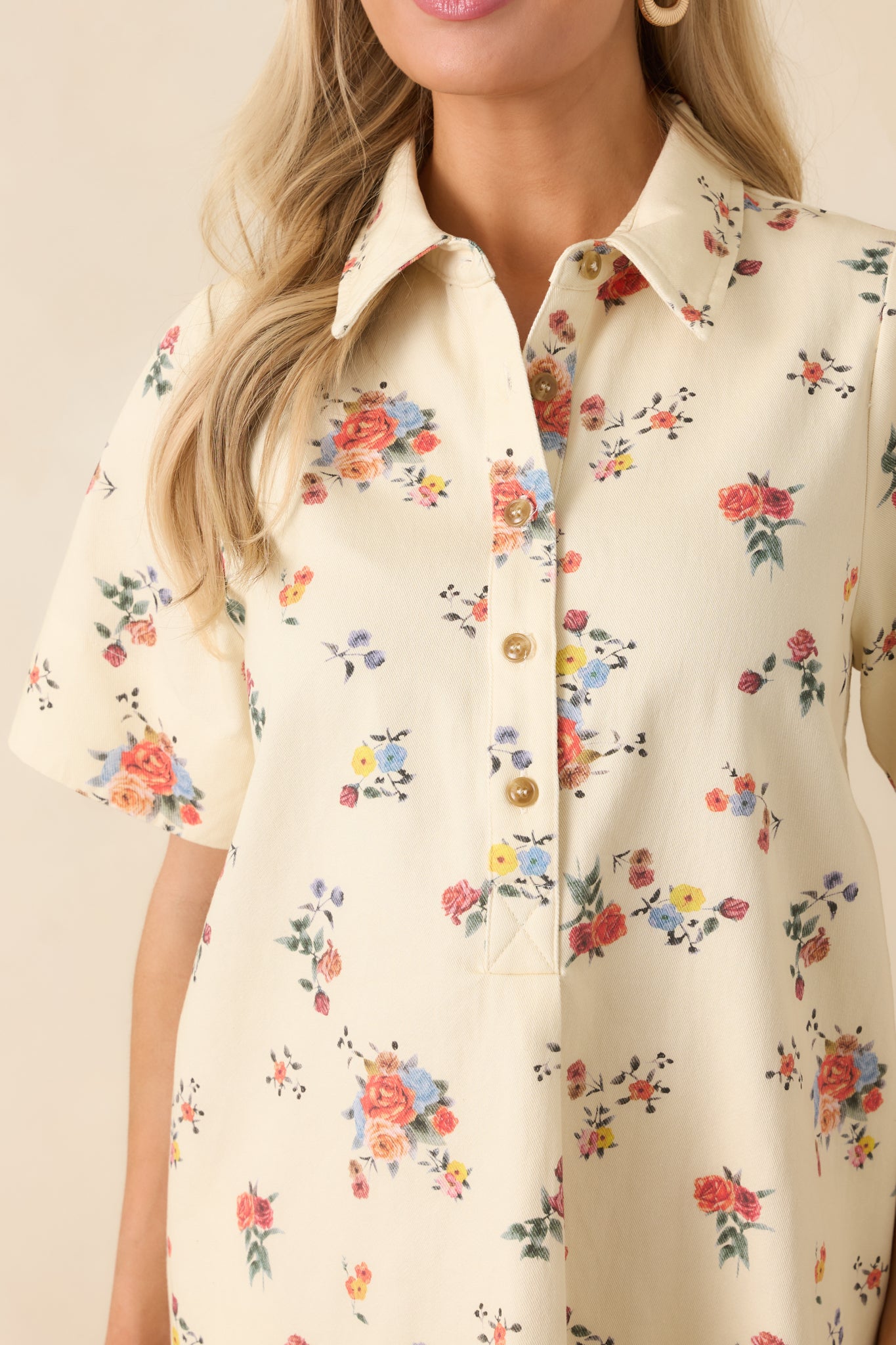 Cream floral cotton fabric featuring the collared neckline and button-front placket with structured finish.