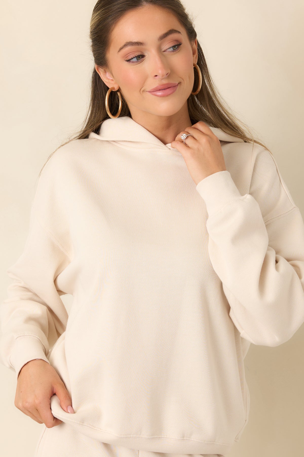 Soft cream hoodie with a roomy hood and relaxed neckline.