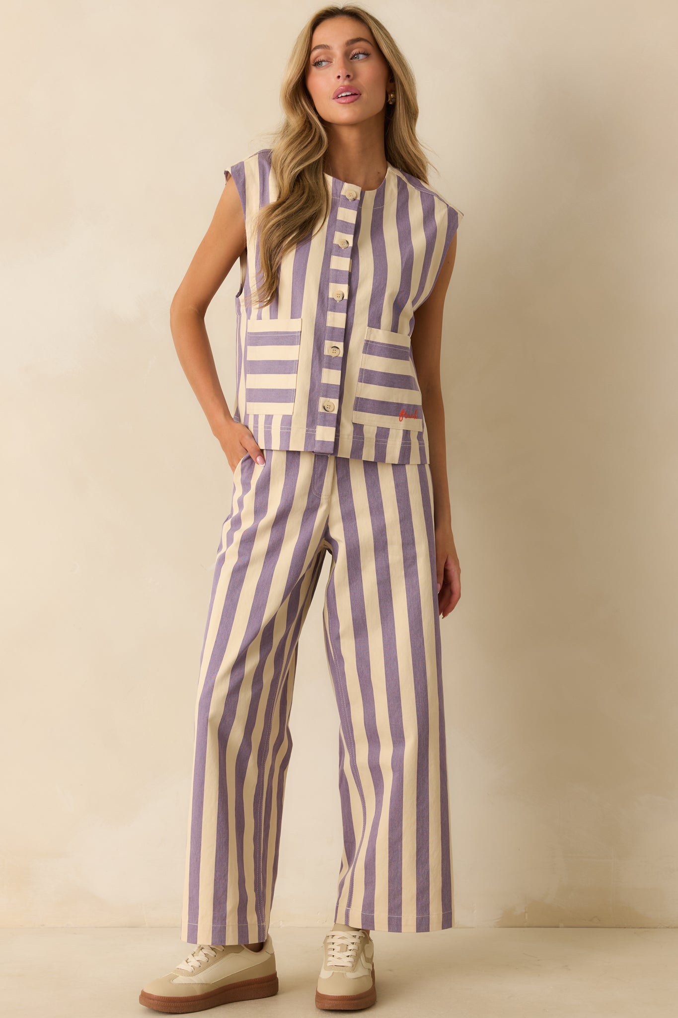 Tailored cotton vest in cream and lilac vertical stripes displayed to highlight its clean lines and playful pattern.
