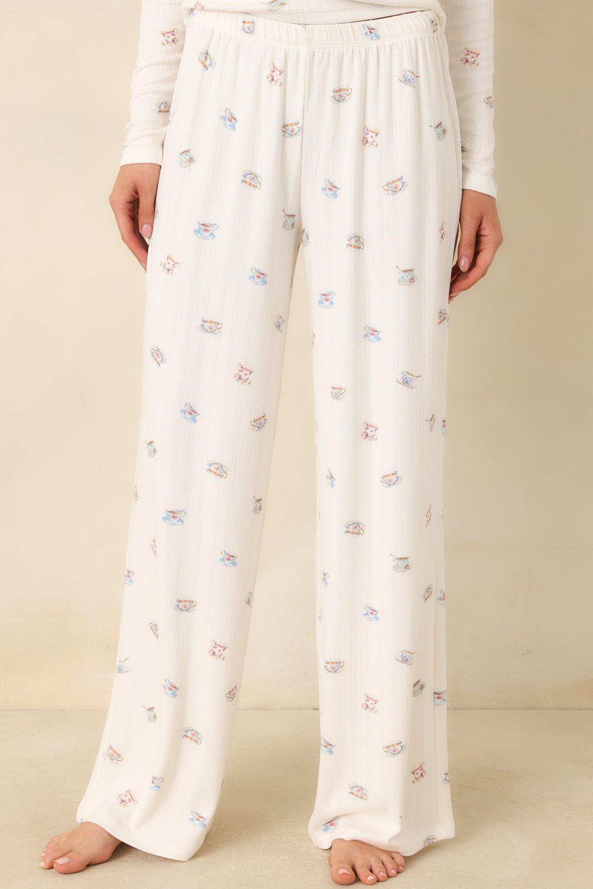 Cream pants with an elastic waistband and delicate allover teacup print.