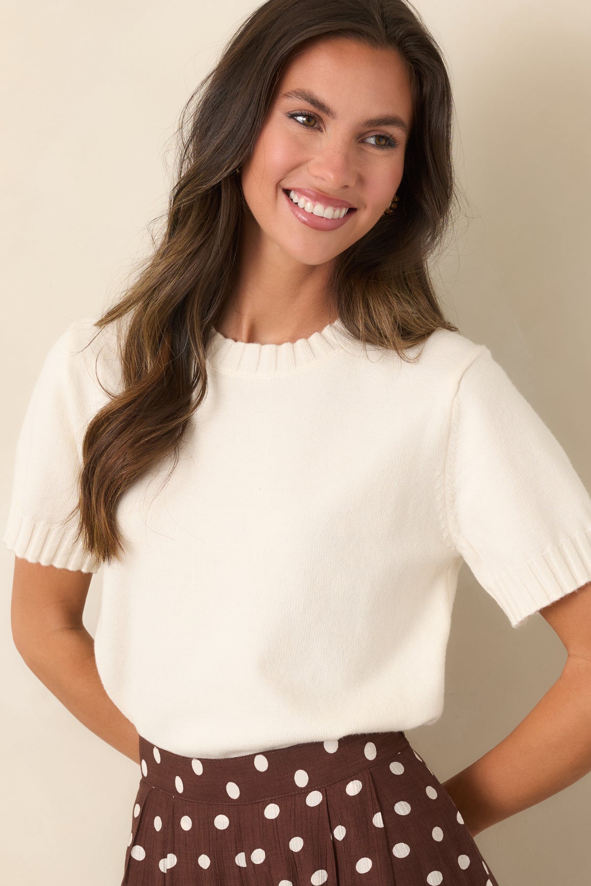 Creamy ivory knit top with a classic crew neckline and textured ribbed trim.