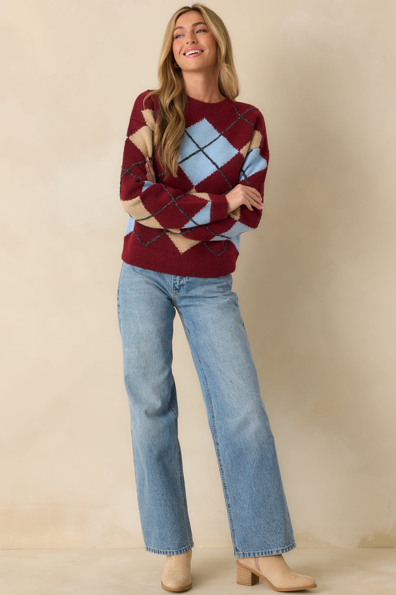 Crew-neck burgundy sweater with classic argyle pattern in complementary colors.