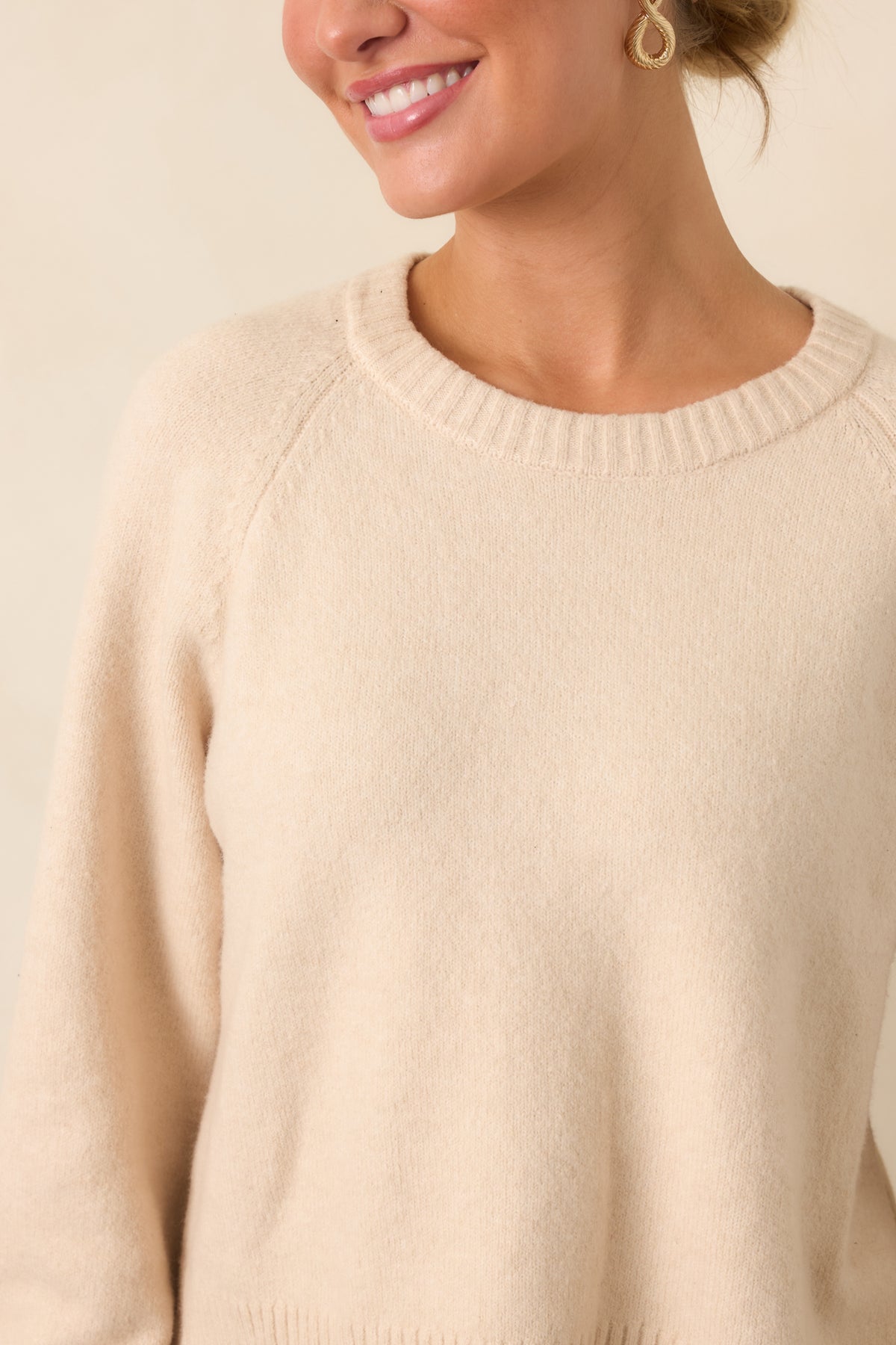 Close view of the crew neckline with ribbed trim and softly gathered raglan sleeve construction.