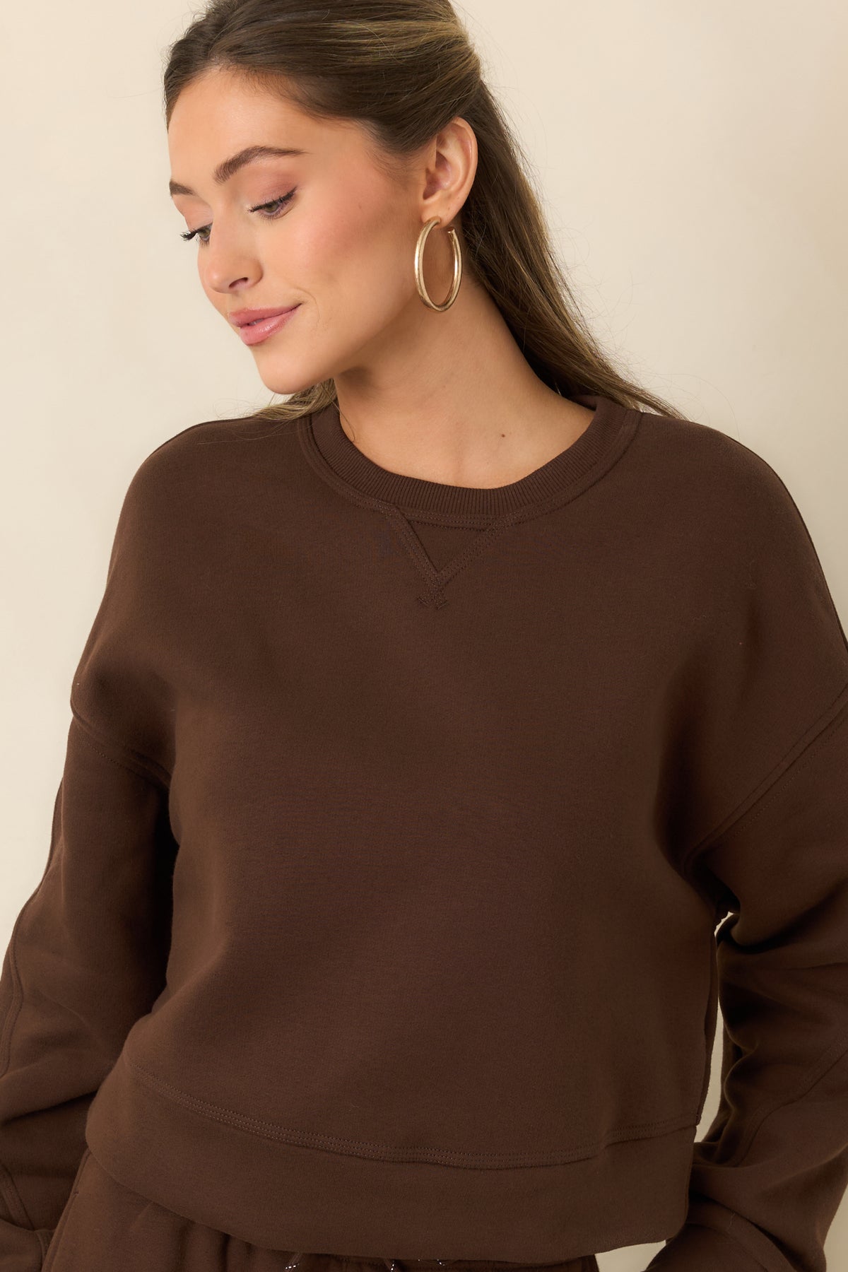 Crewneck fleece top with ribbed neckline trim and a subtle V-stitch detail.