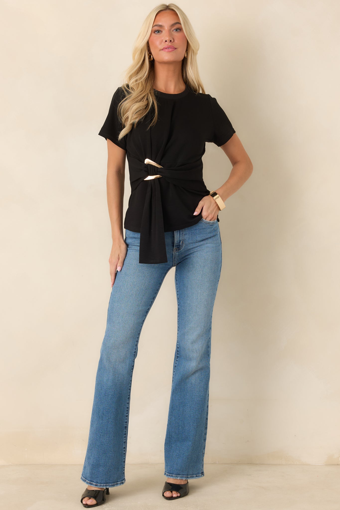 Crewneck top featuring a sculptural buckle detail, short sleeves, and a sleek, tailored shape.