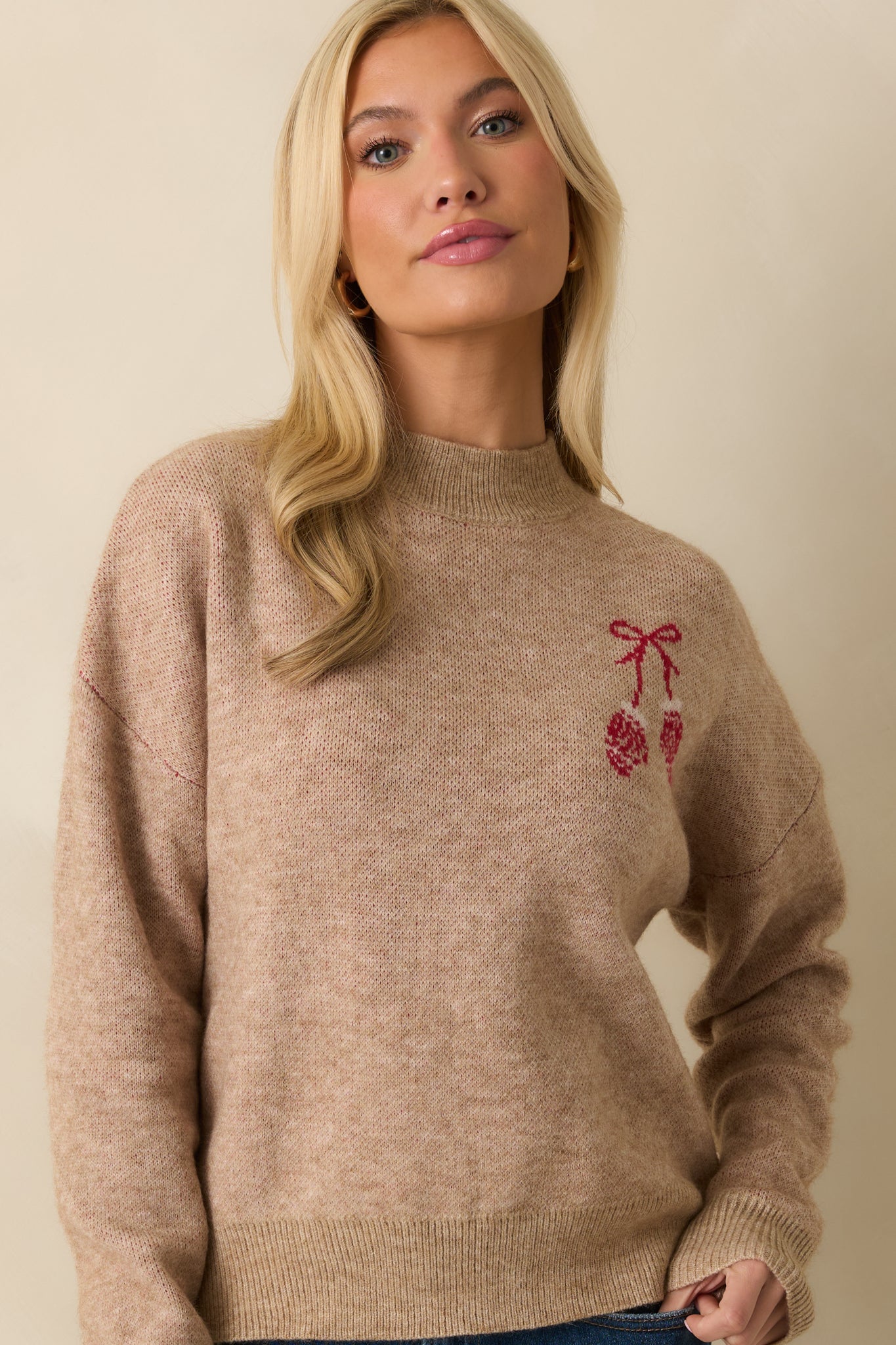 Crop highlighting the ribbed cuffs and festive mitten embroidery on the chest.