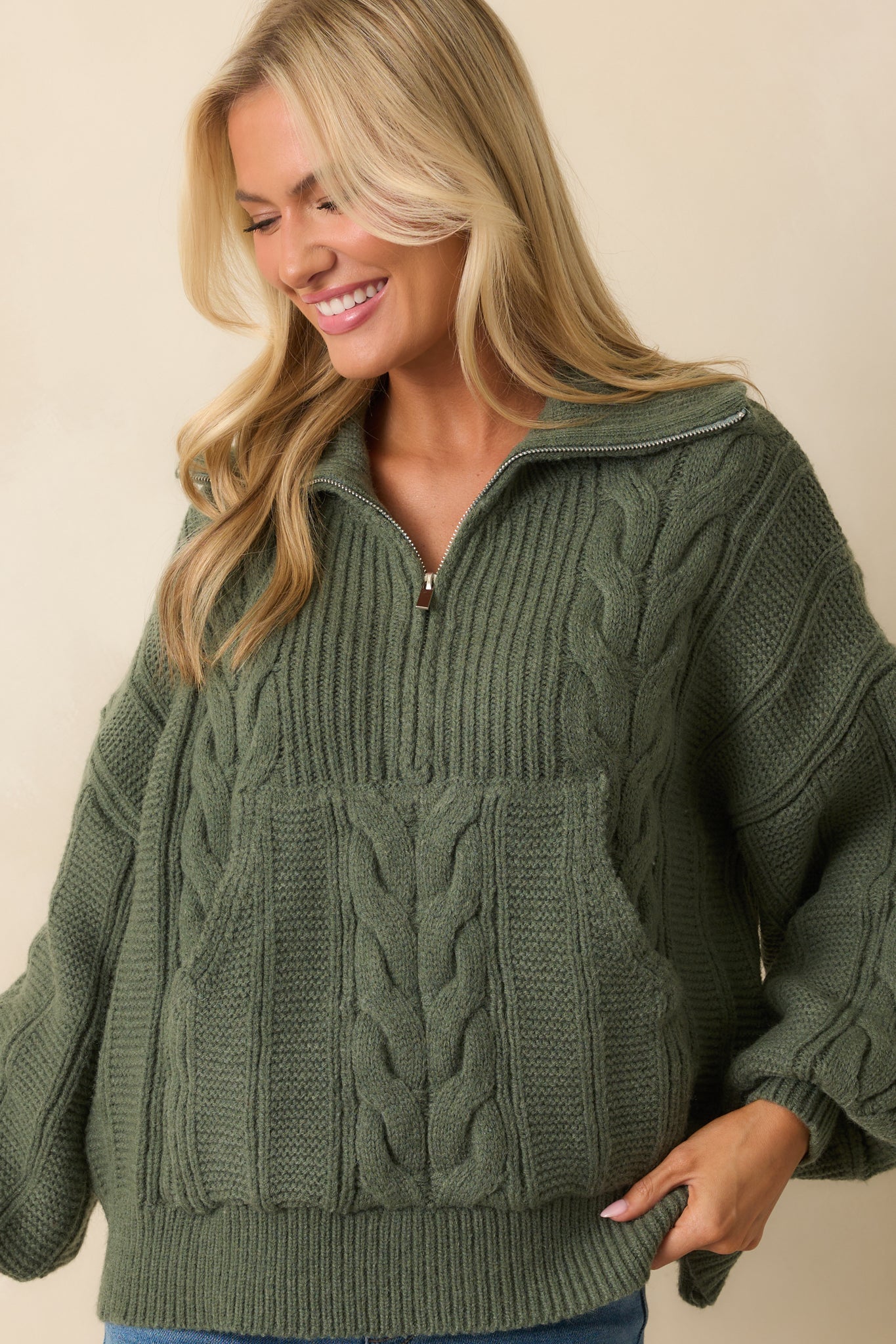 A cropped close-up emphasizing the oversized silhouette with a quarter zip closure and ribbed trim.