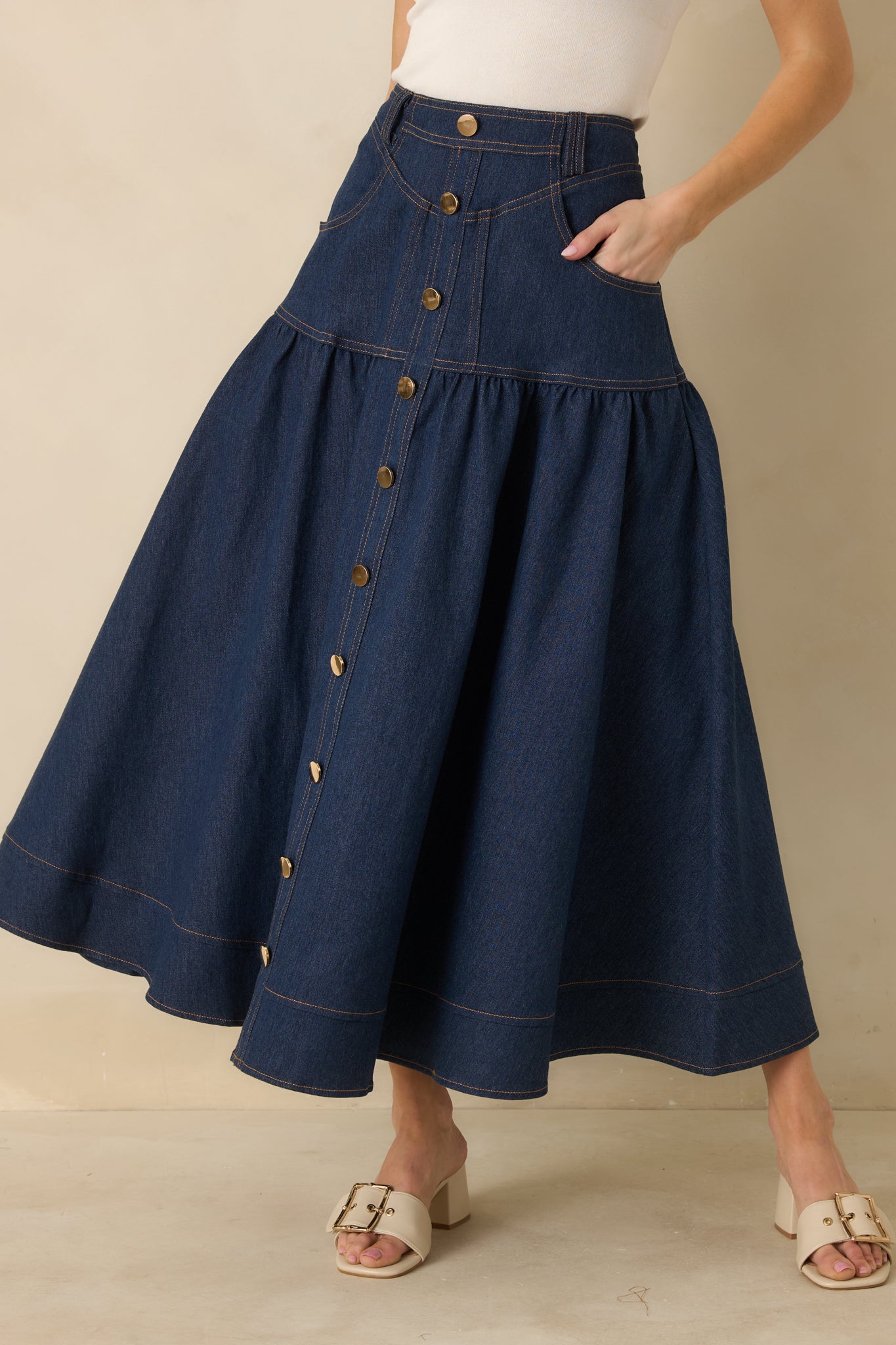 Angled crop image of the dark wash skirt highlighting the front pockets and smooth denim texture.