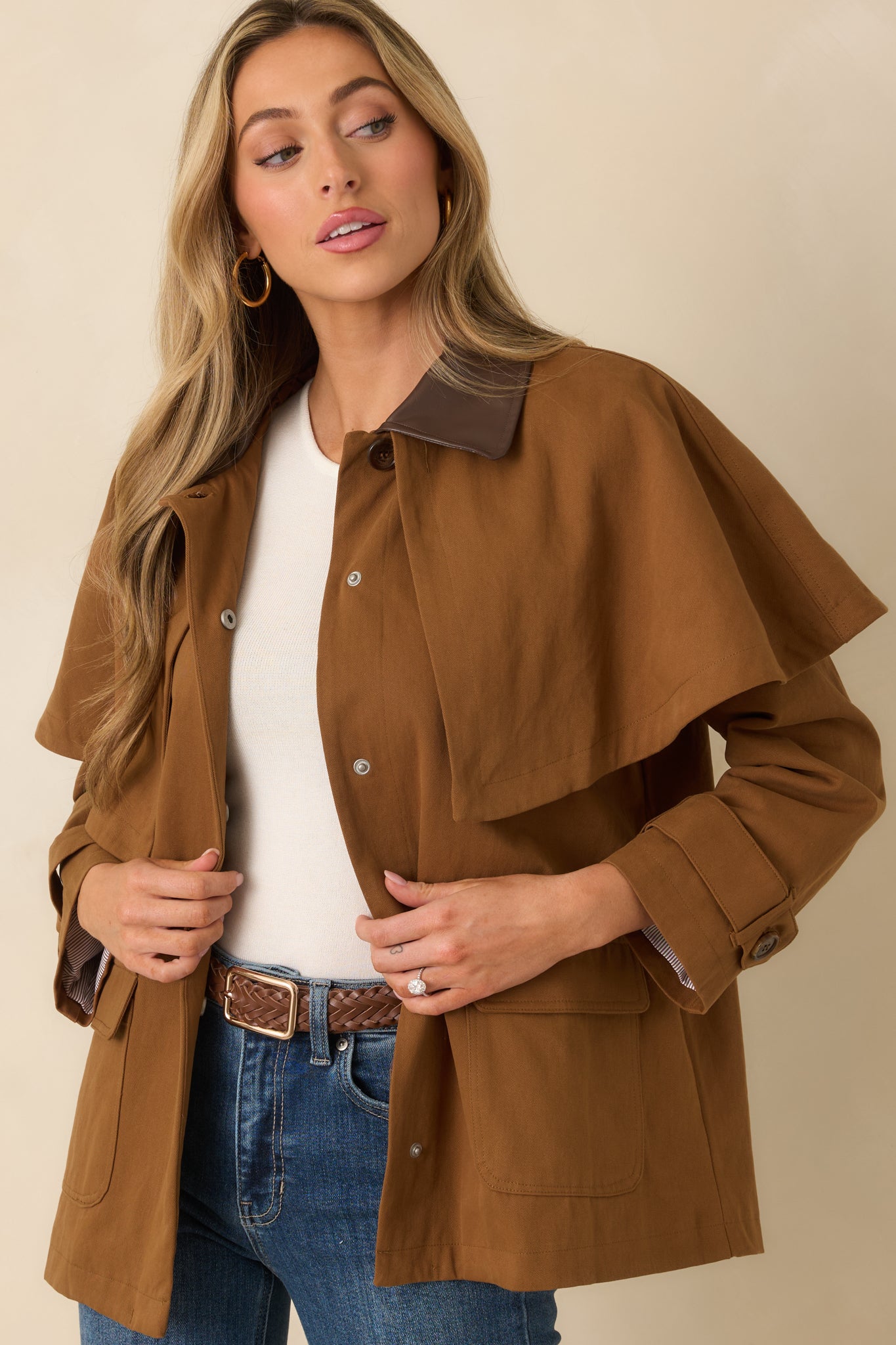 Front-centered crop showing button detail and stitching of brown structured utility jacket.