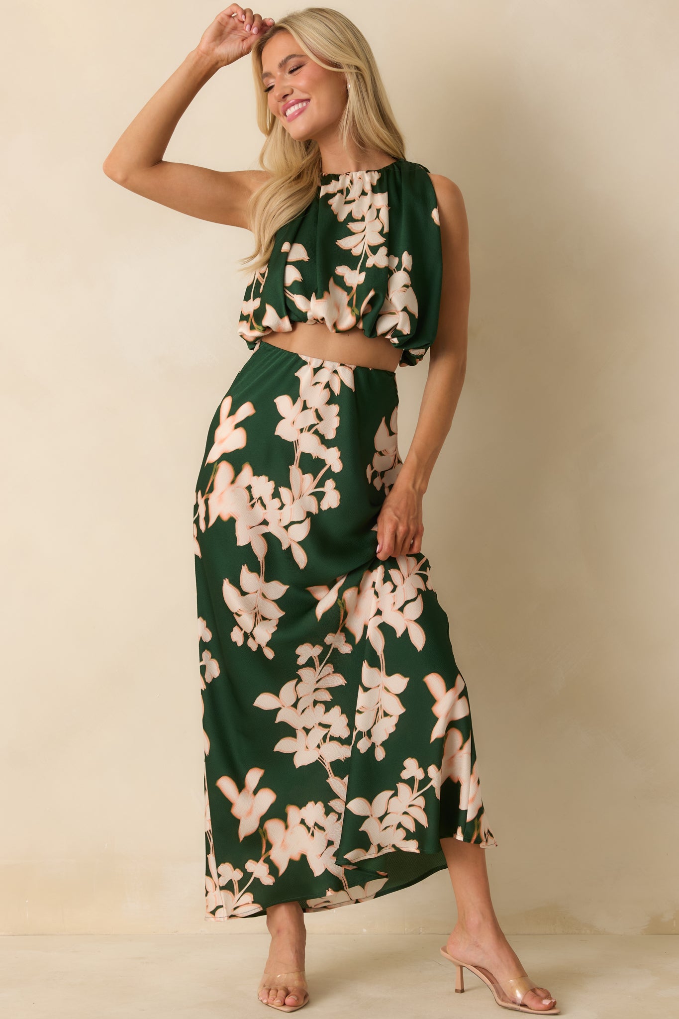 The crop top shows its green floral hammered satin fabric with a gathered halter-style neckline and soft volume from the elasticized hem.