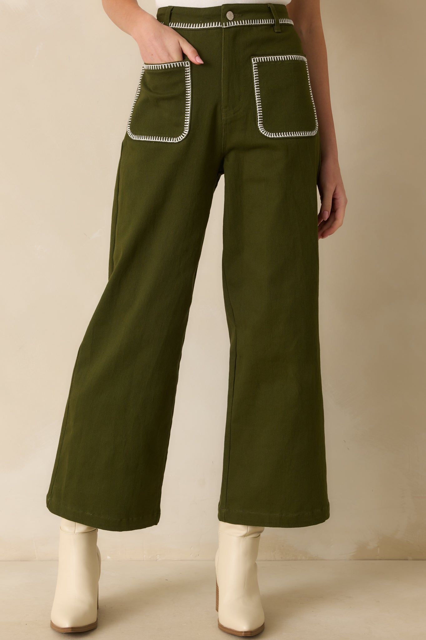 Cropped angle highlighting the fabric texture and olive green color of the jeans.