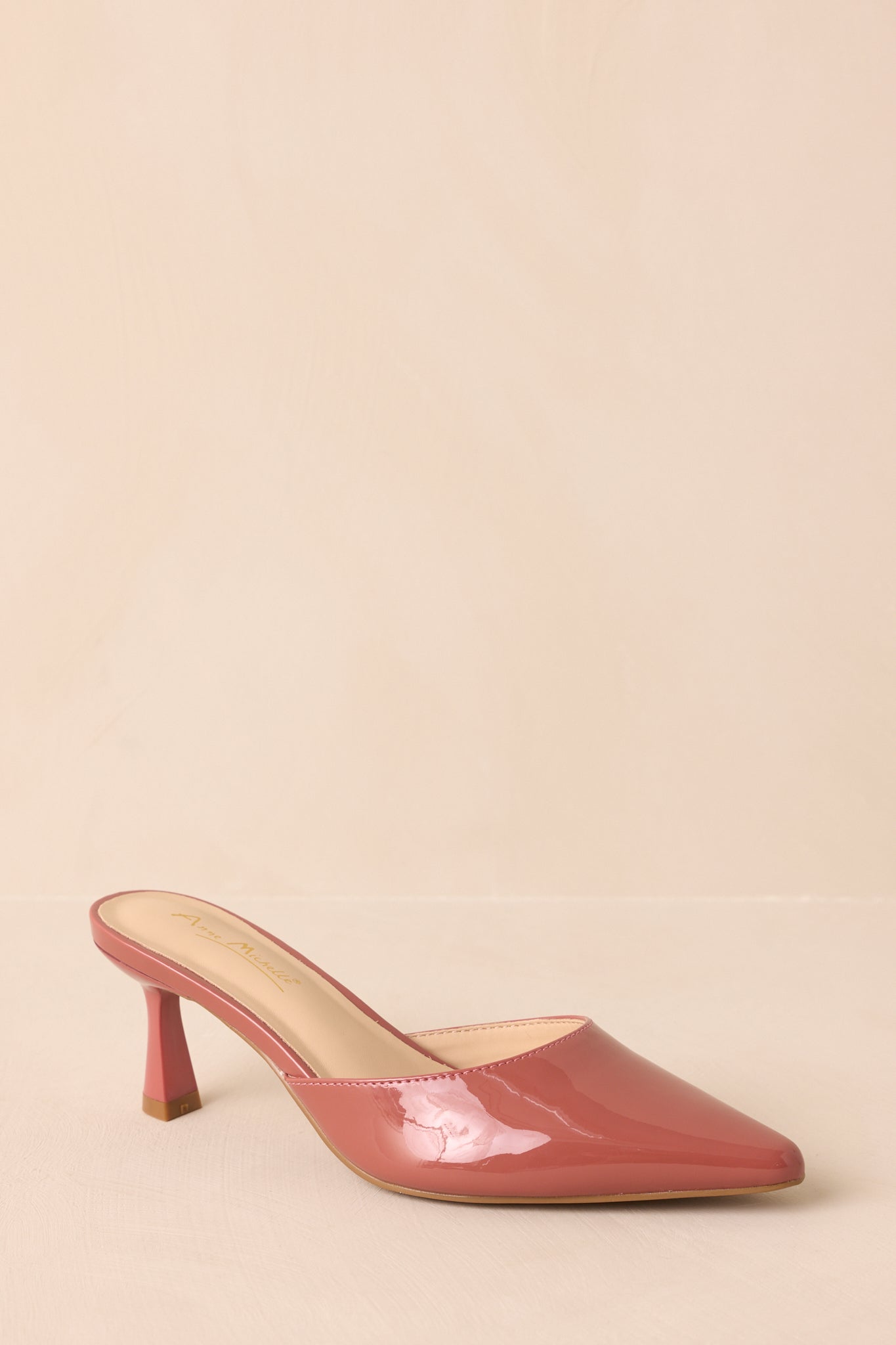 A cropped angled view focusing on the shiny rose pink upper and sleek mule design.
