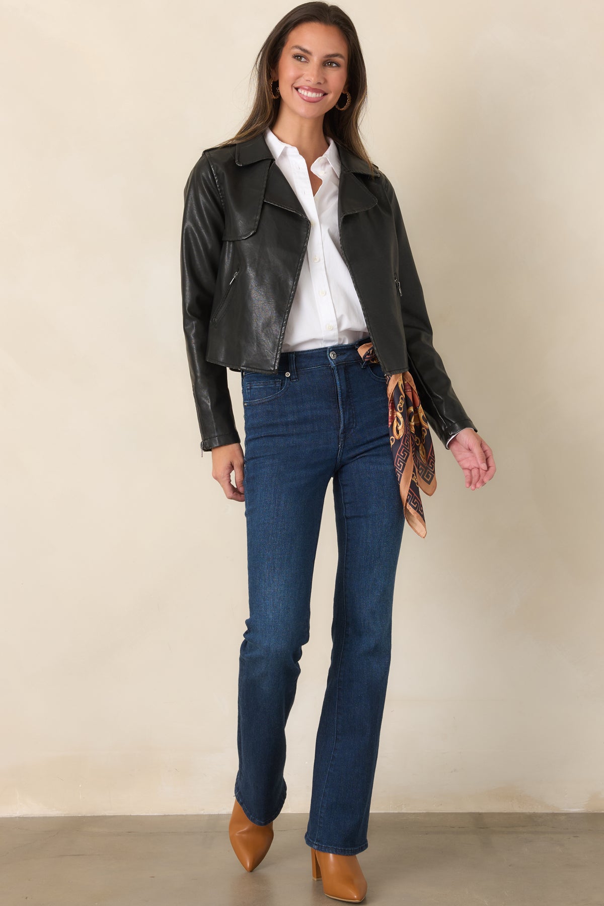 Cropped black faux leather jacket featuring wide notched lapels, an open front, and zippered side pockets.