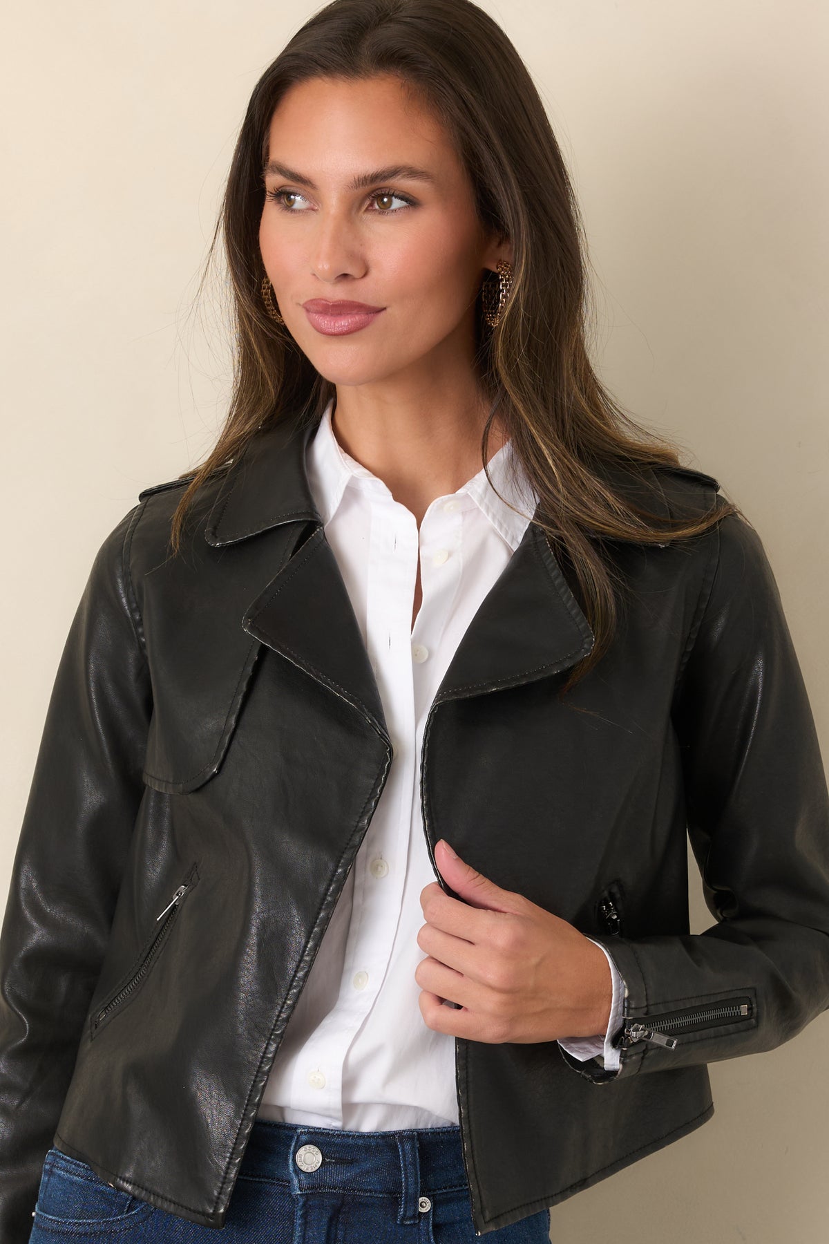Cropped black faux leather jacket with an open front and zippered side pockets.