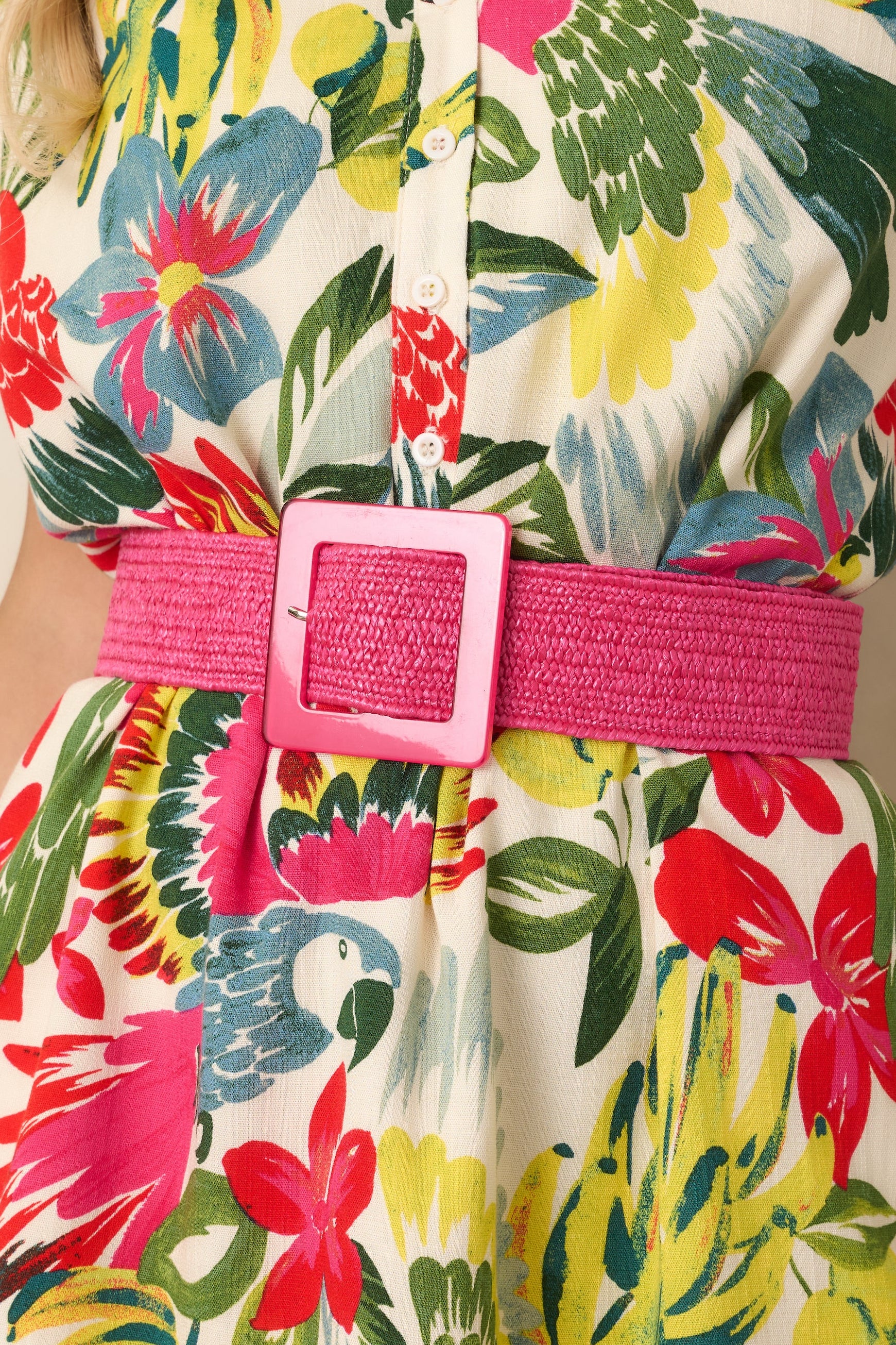 Cropped view of bright pink belt highlighting textured elastic material and vibrant buckle