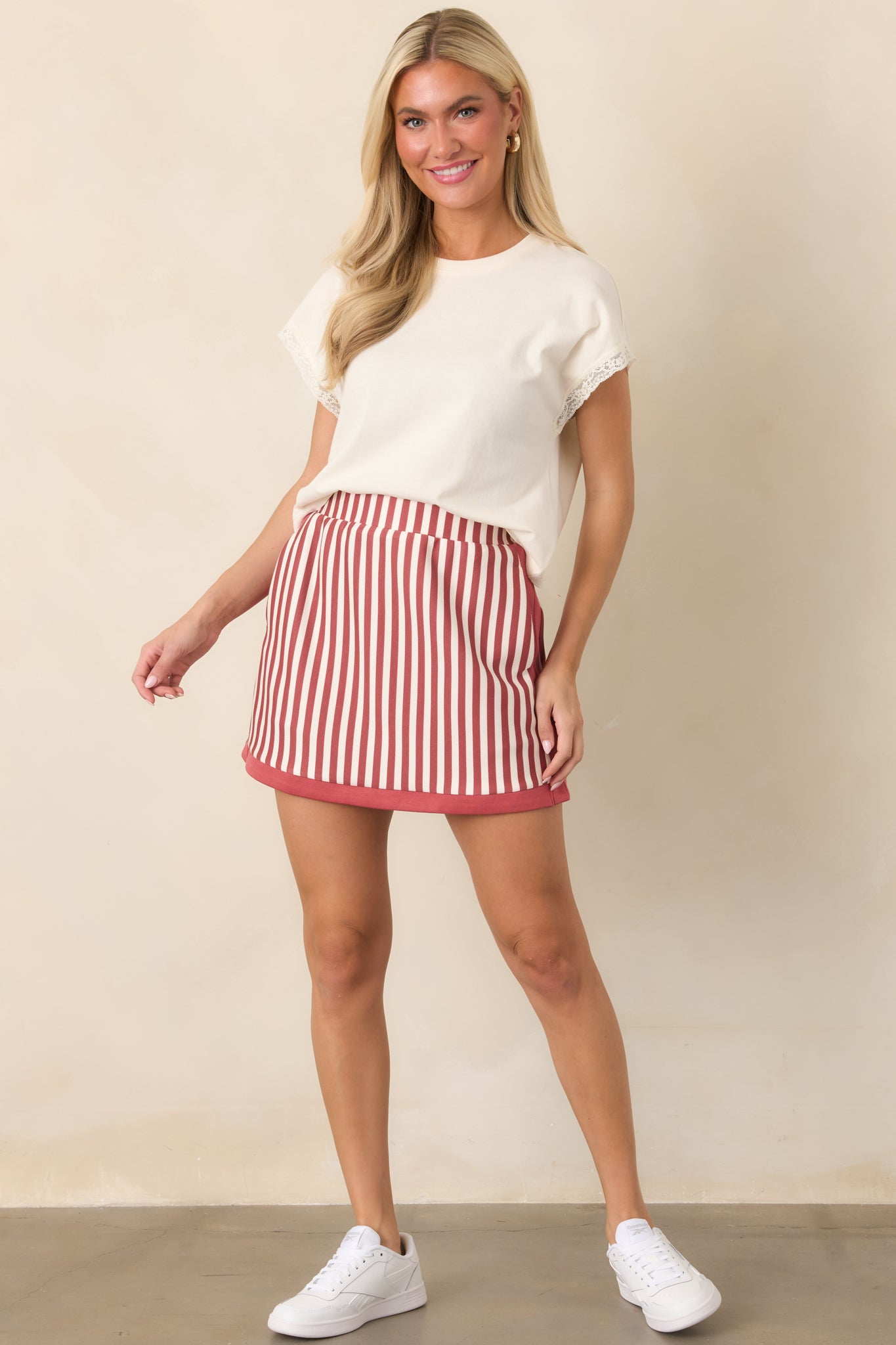 Slightly cropped top featuring structured cap sleeves accented with feminine lace trim and a simple crew neckline.