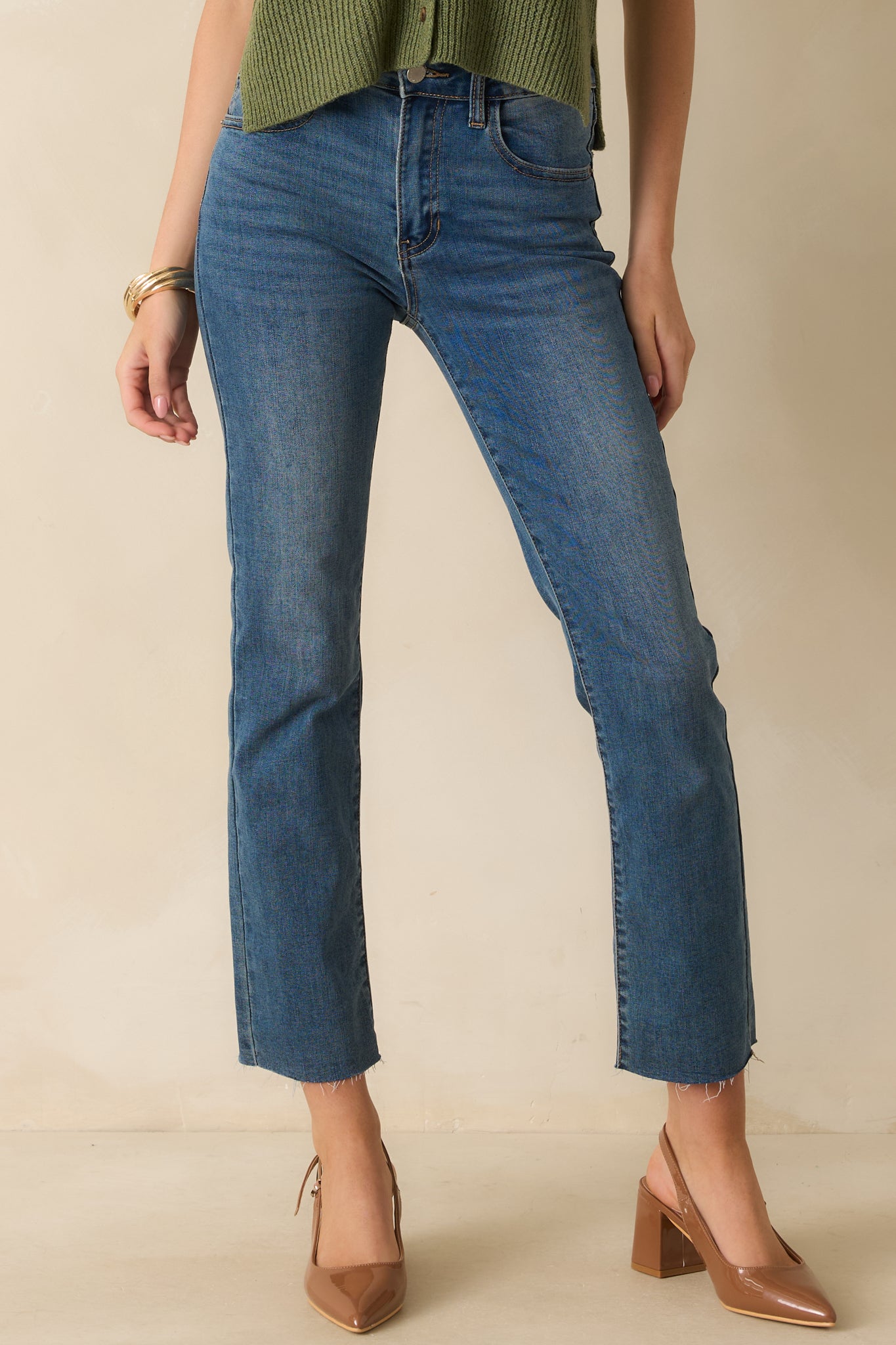 Cropped view of dark wash jeans highlighting high rise waist and belt loops.