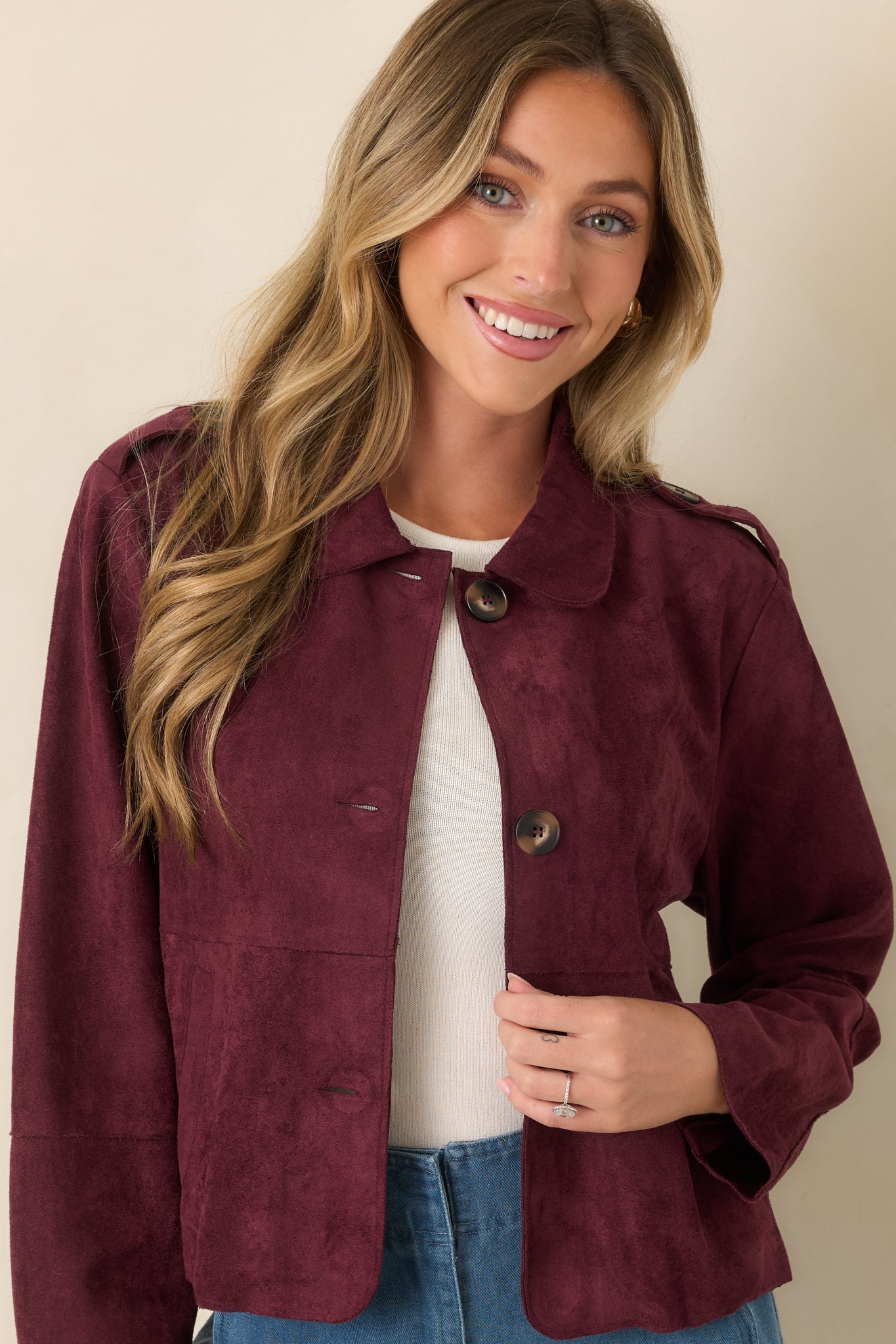 Detailed front view of the cropped faux suede jacket showcasing oversized patch pockets, functional buttons, and a softly structured silhouette.