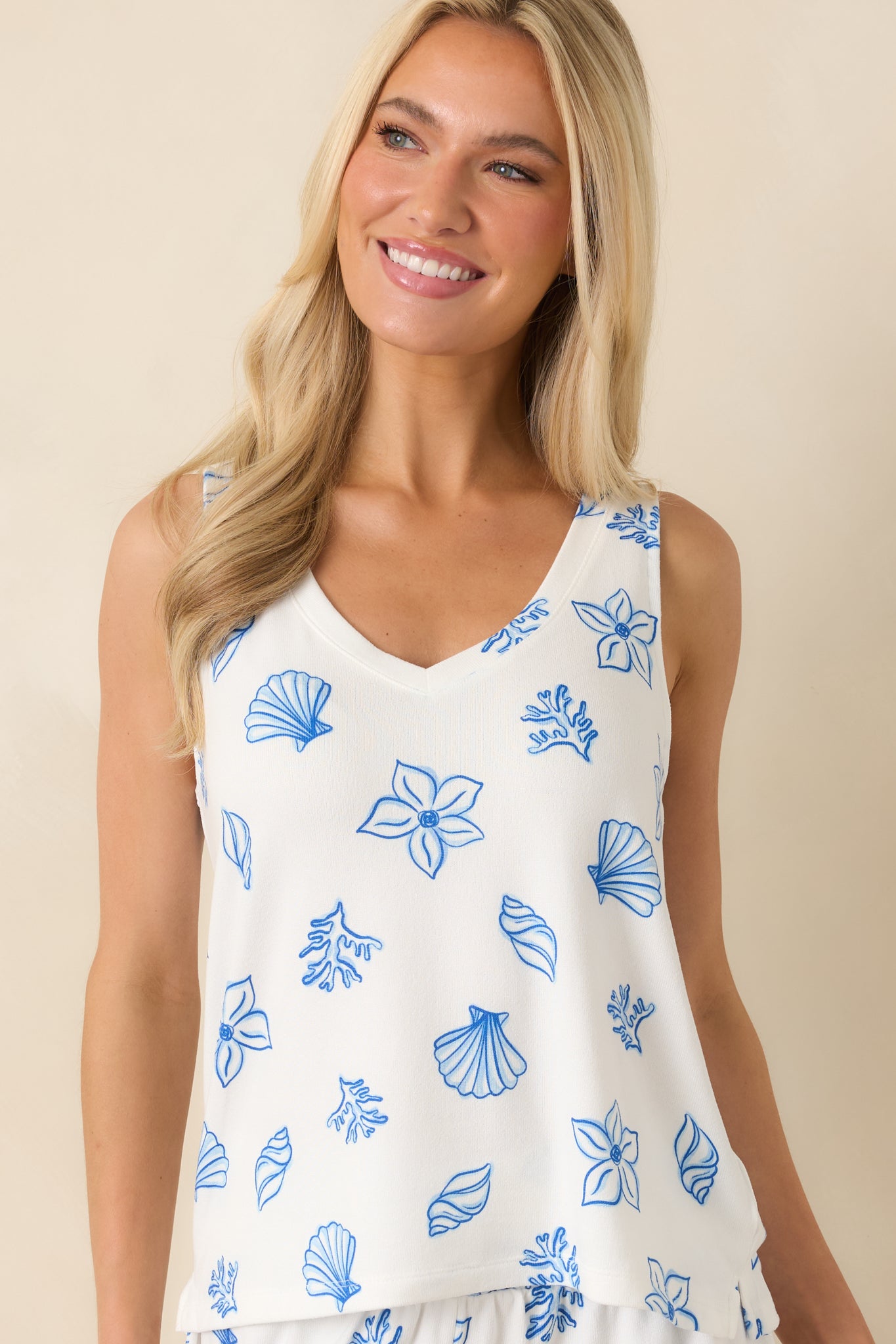 Cropped view focusing on the blue coastal-inspired print featuring seashell, coral, and floral motifs.
