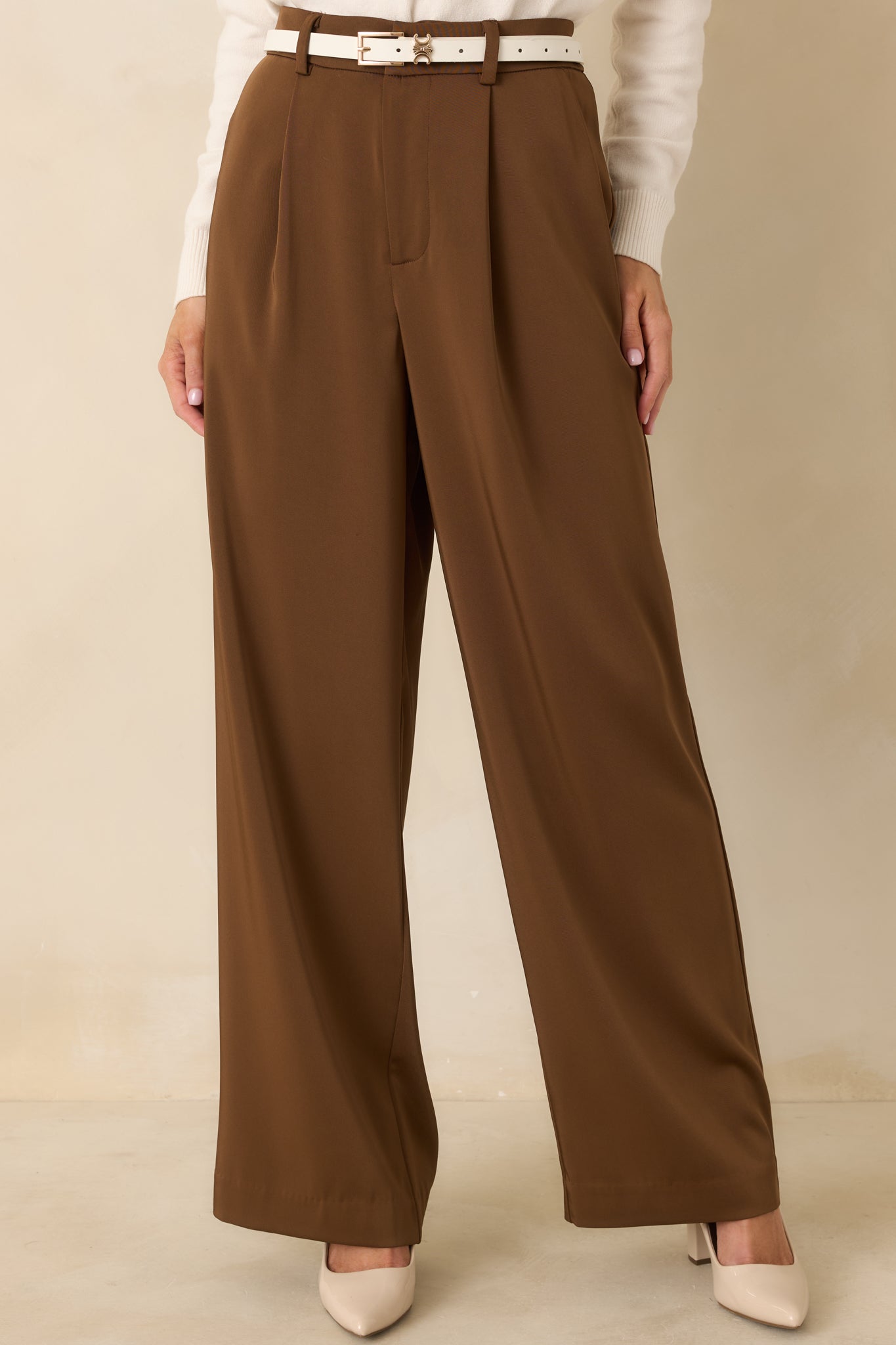 Cropped front view focusing on the high-rise waist, belt loops, and pleated front detailing.