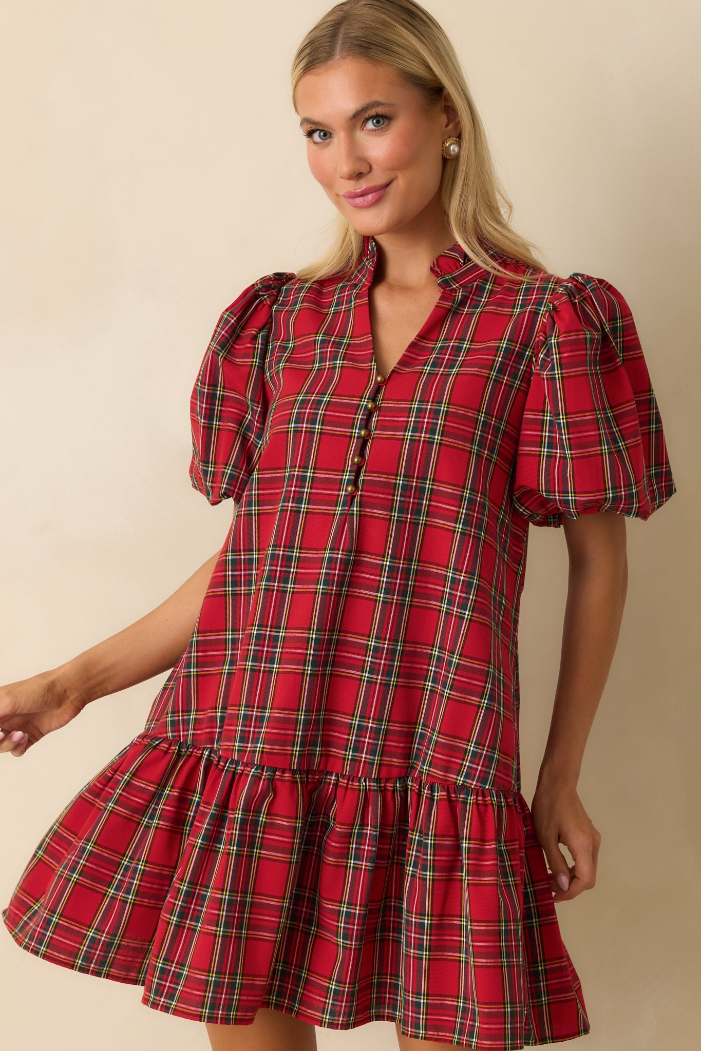 Front-focused crop highlighting ruffled drop hem and side pocket on the red plaid dress.
