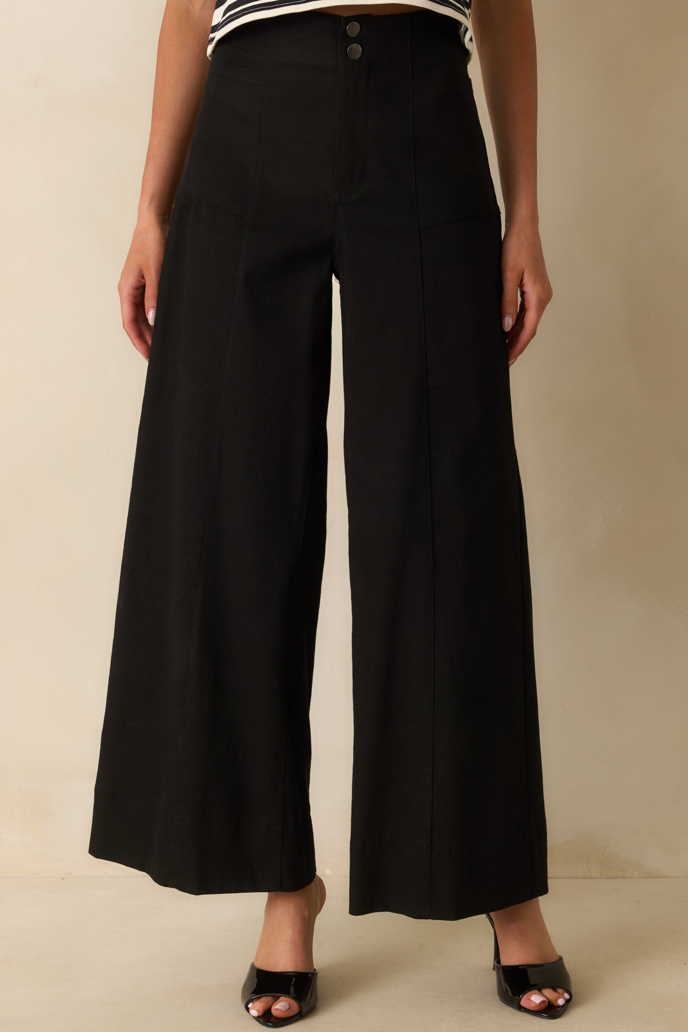 A cropped front view focusing on the high-waist design and button zipper detail.