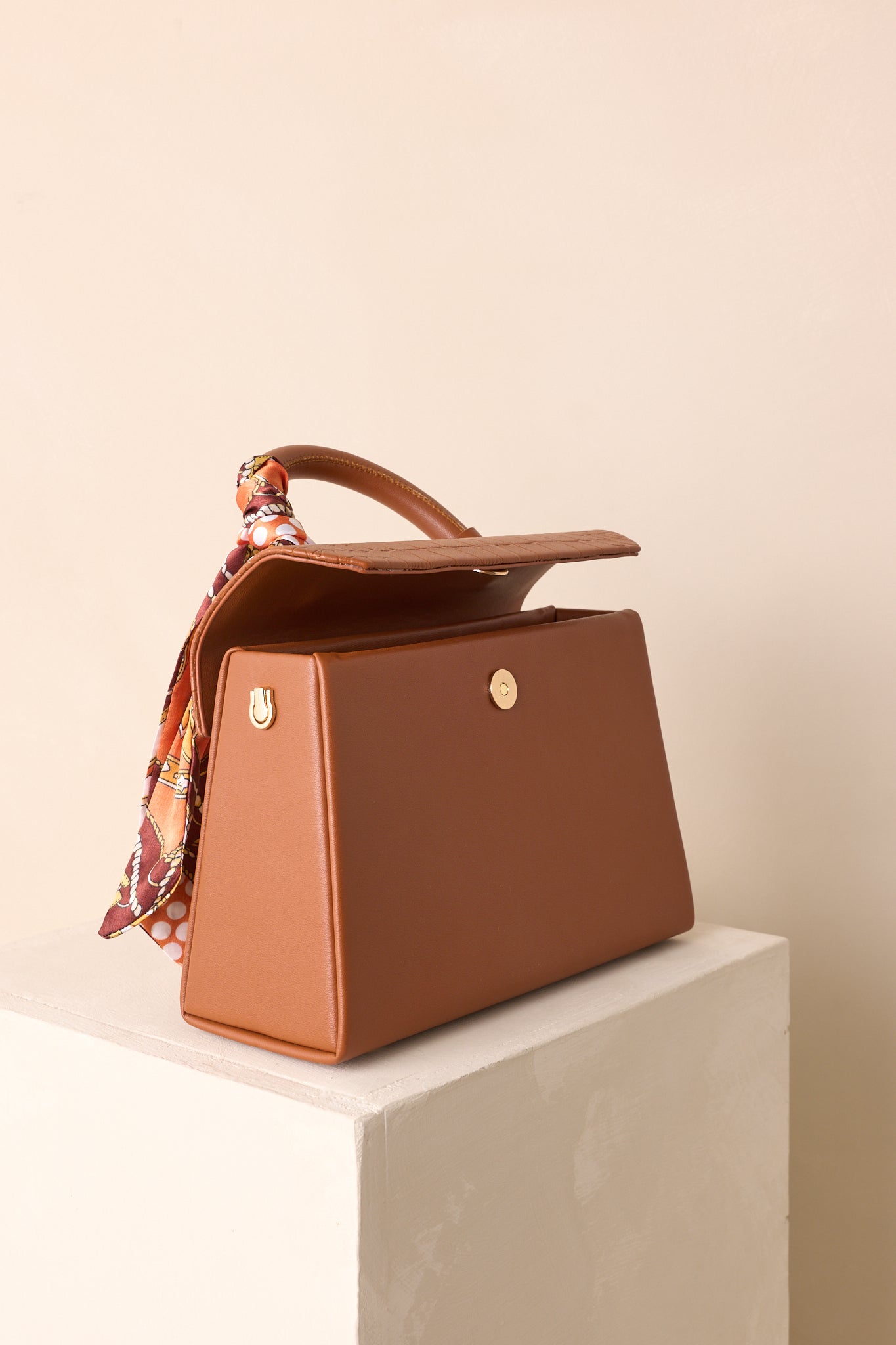 A cropped front view highlighting the magnetic flap closure and structured silhouette.