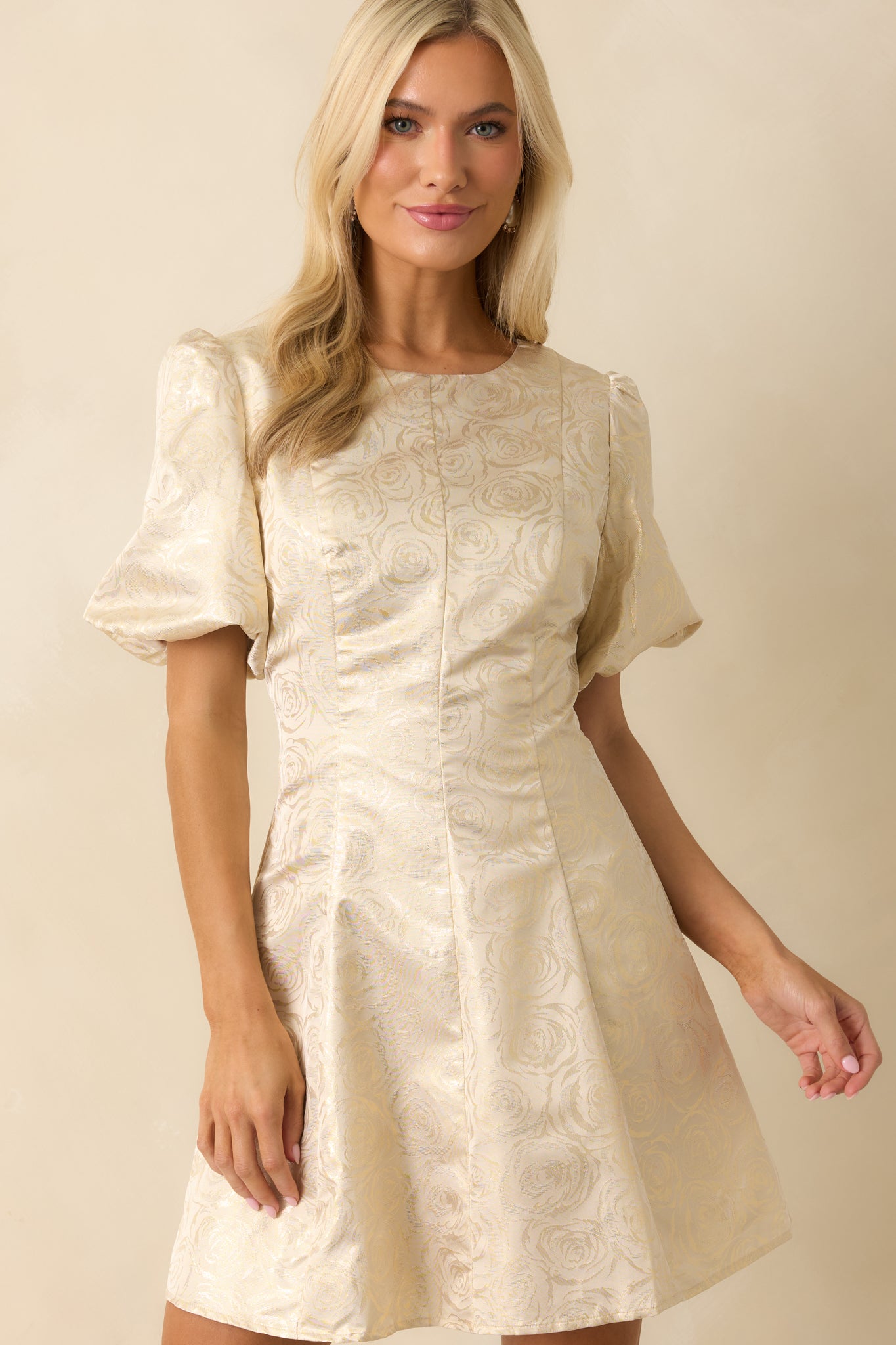 Cropped front view showing puff sleeves and neckline seam detail in the floral jacquard fabric.