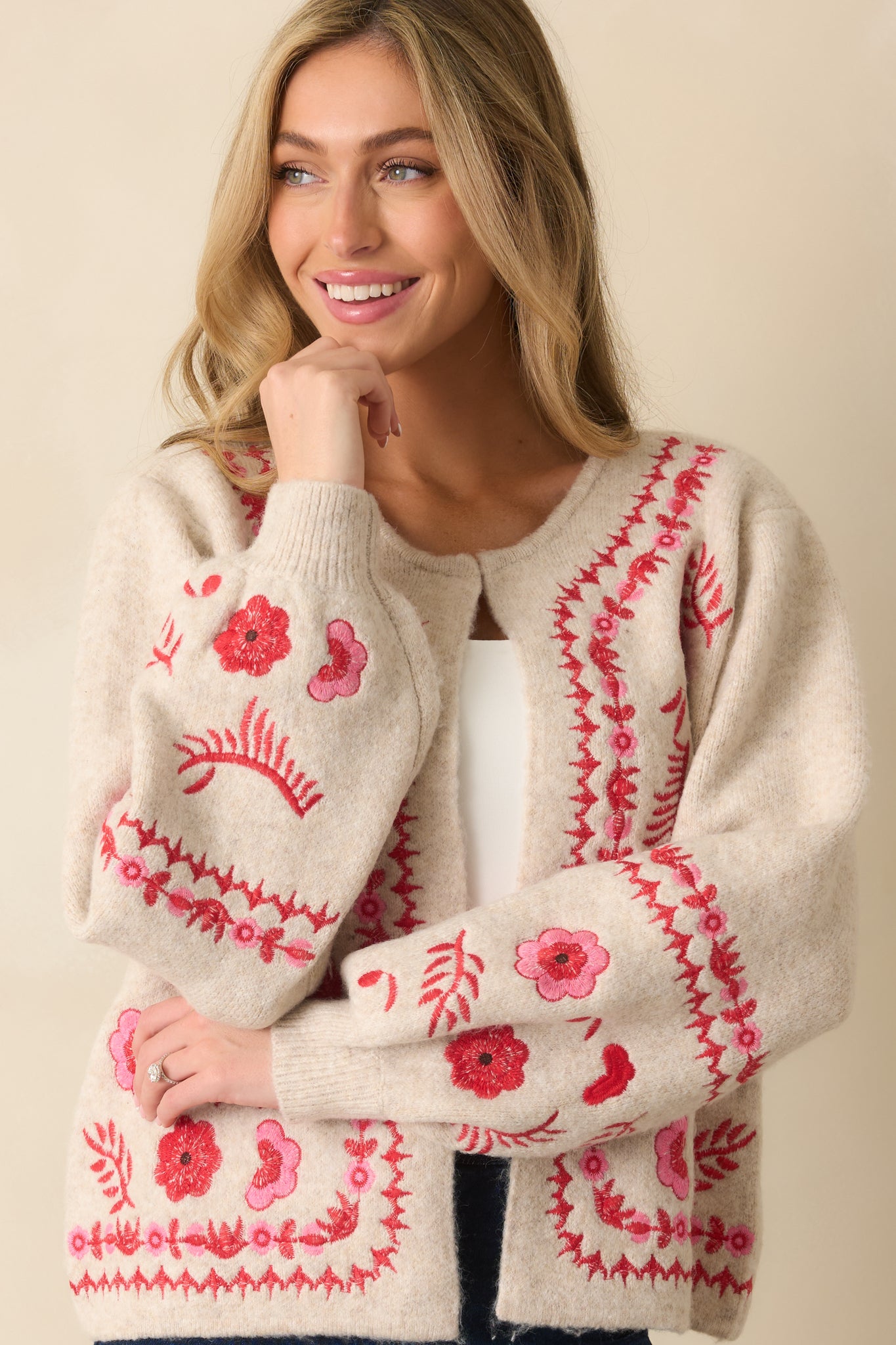 Cropped front view capturing the ribbed hem and embroidery along the lower portion of the cardigan.
