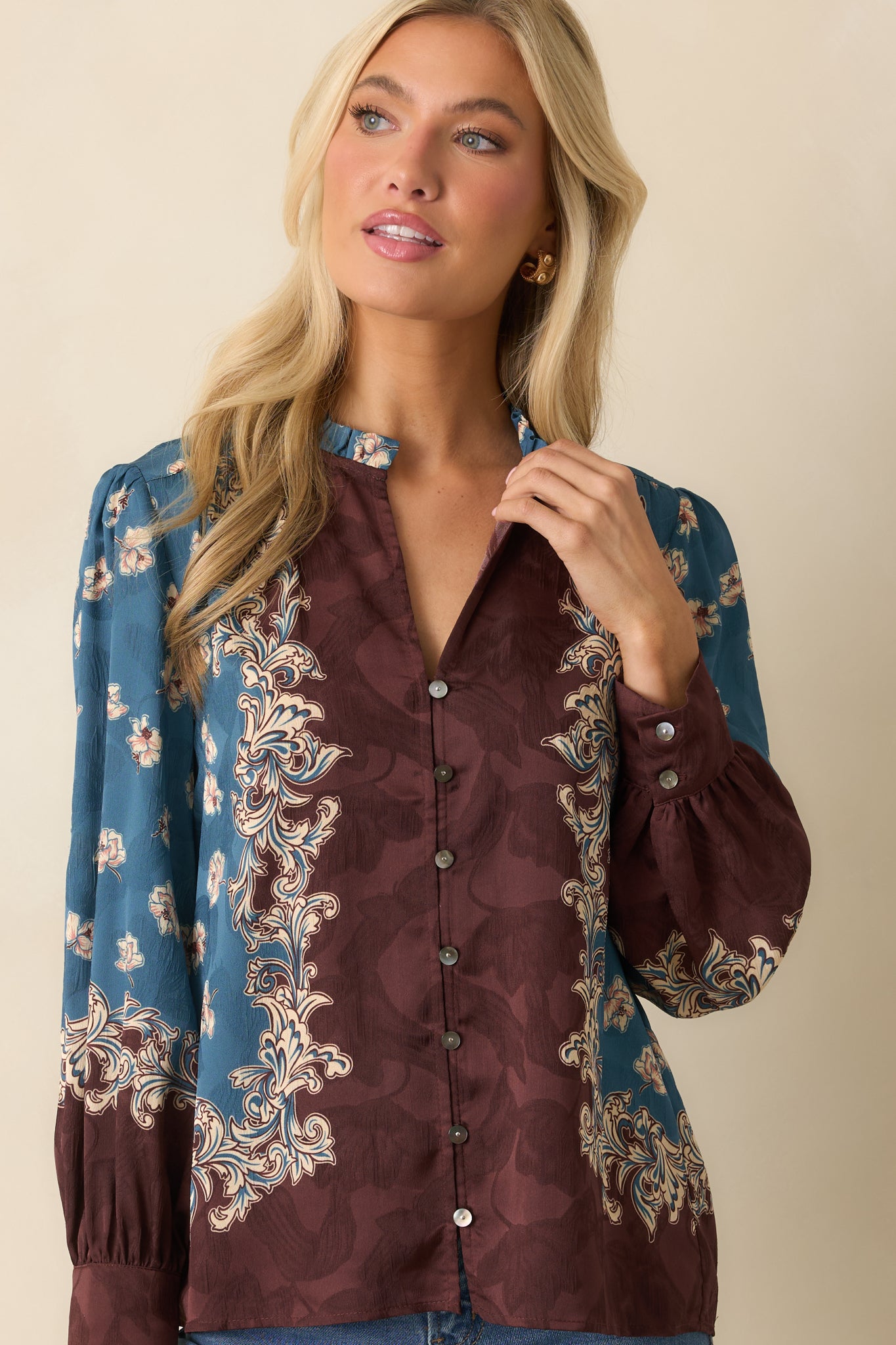 A cropped front view focusing on the split v-neckline and floral border detailing.