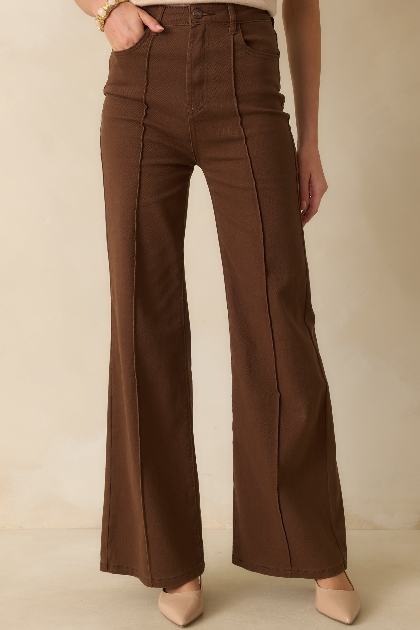 A cropped front view focusing on the waistband, button closure, and front seam detailing.