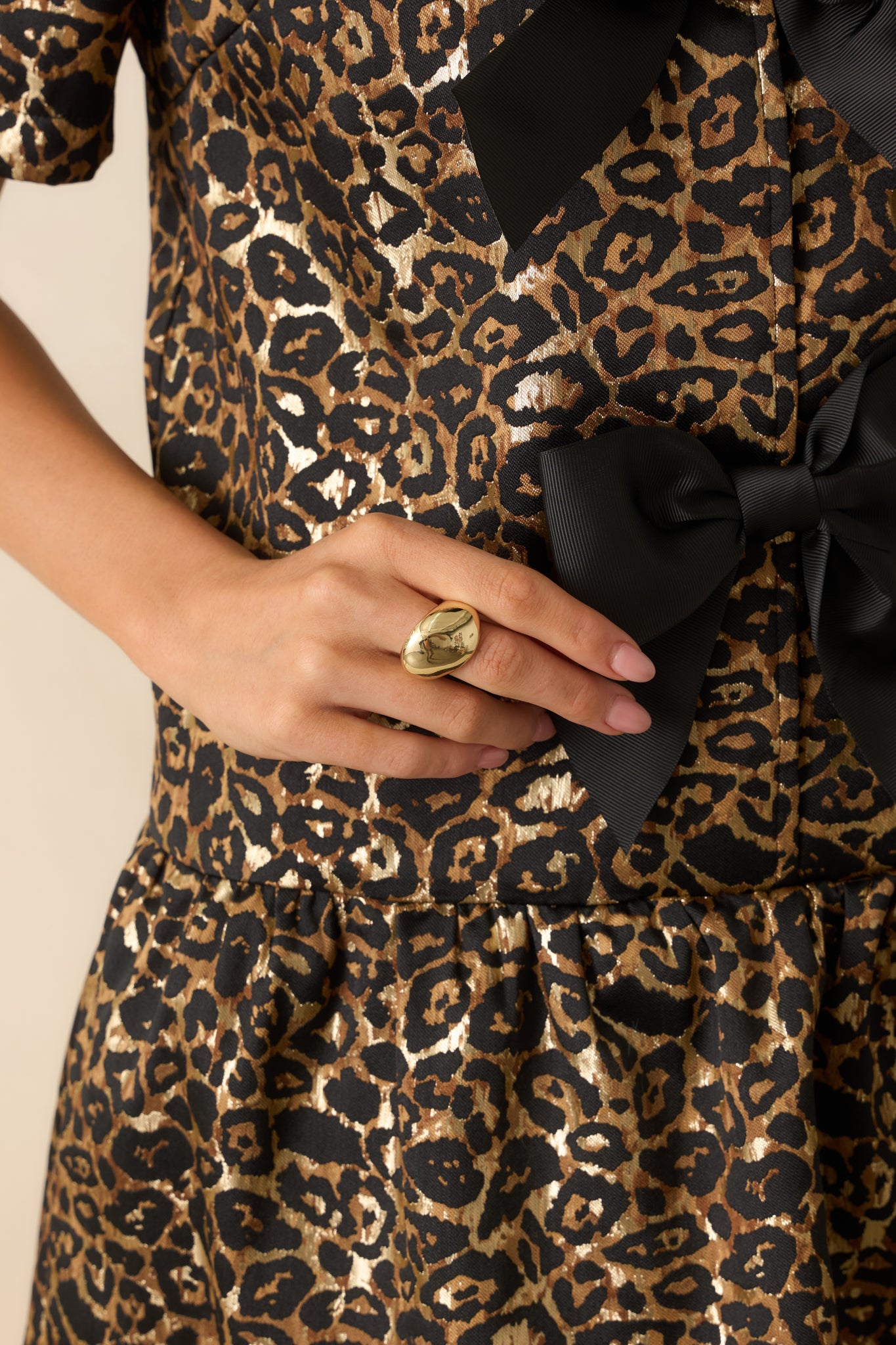 Cropped photo showing the gold statement ring’s wide abstract dome silhouette and reflective polished surface.