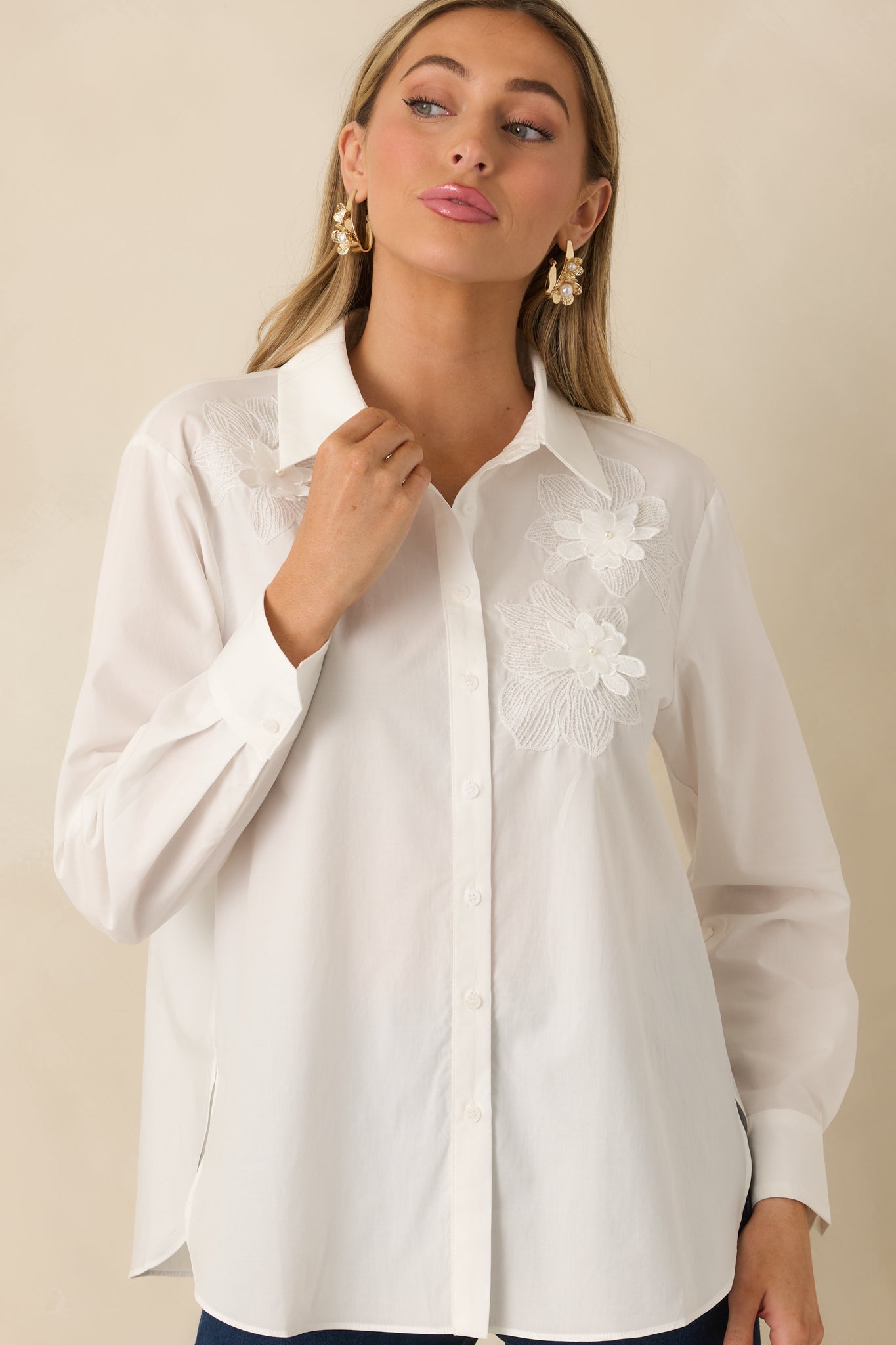 Cropped image focusing on button-front closure and lightweight woven texture of white blouse.