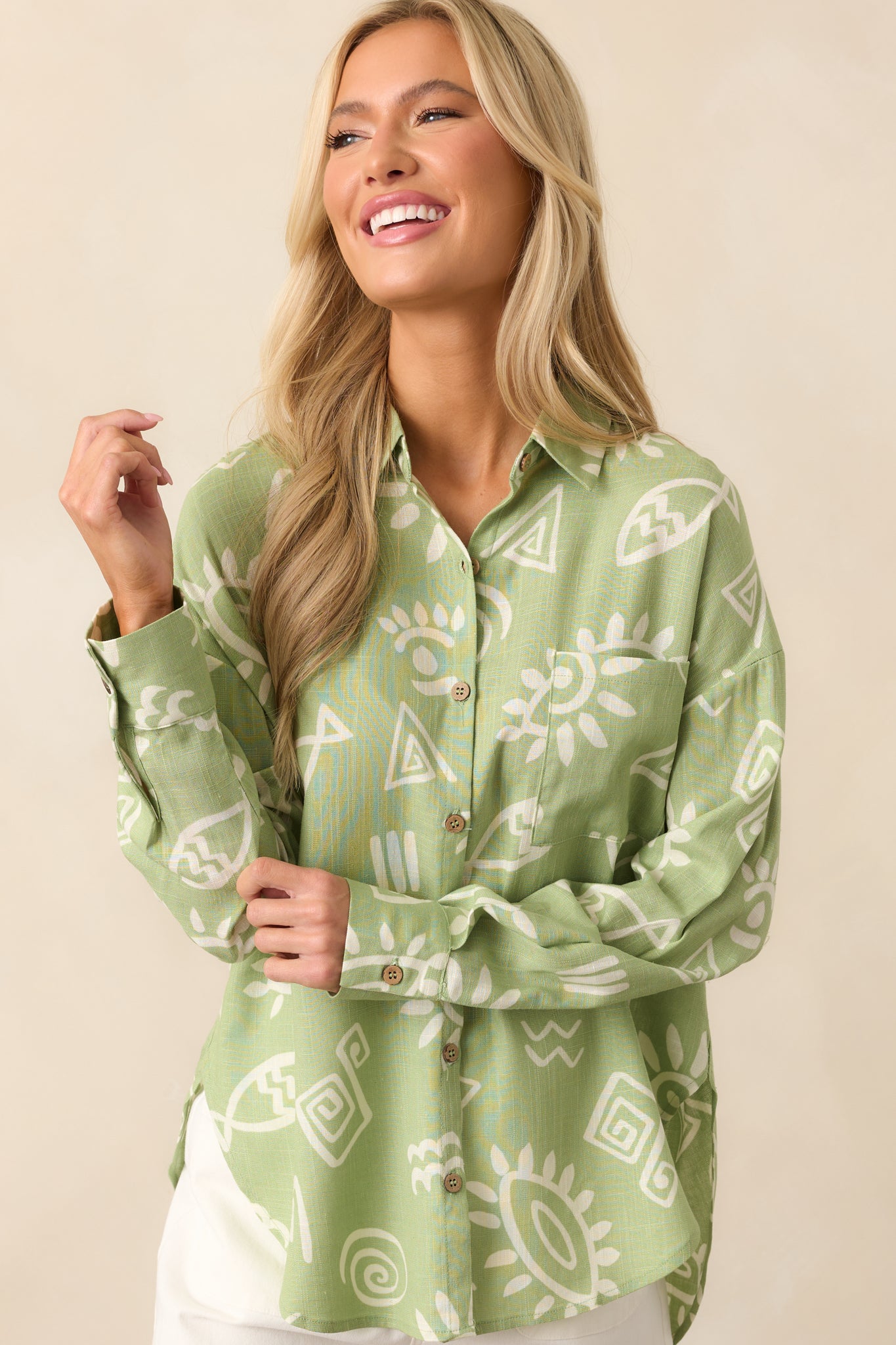 Side view cropped image highlighting the sleeve seam, draped fabric, and subtle texture of the linen blend with tropical print details.