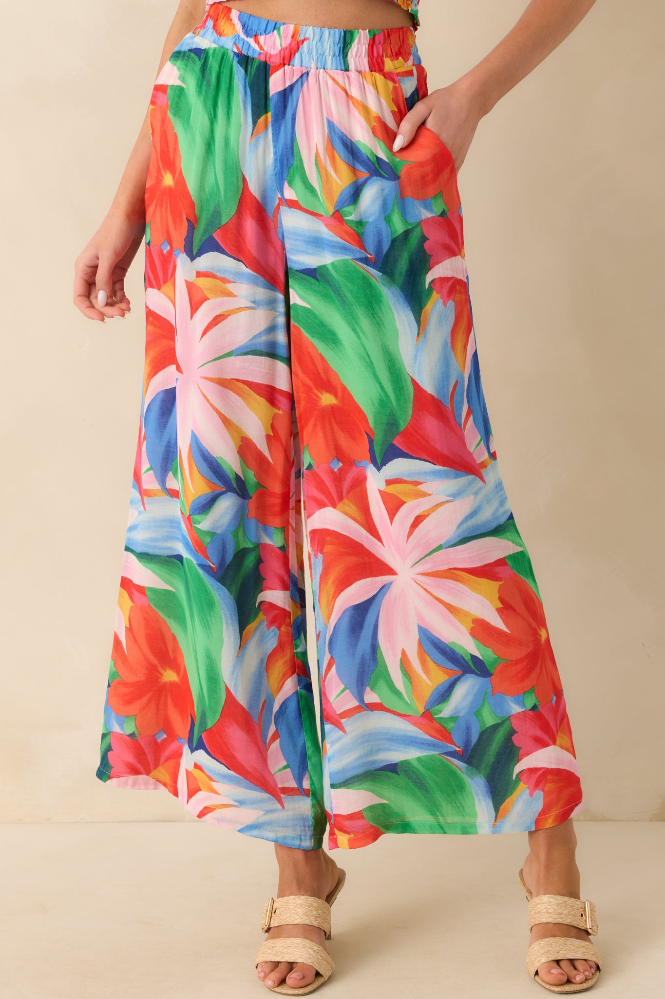 Cropped waist-down image showing the elastic waistband and vibrant floral pattern across the upper portion of the pants.