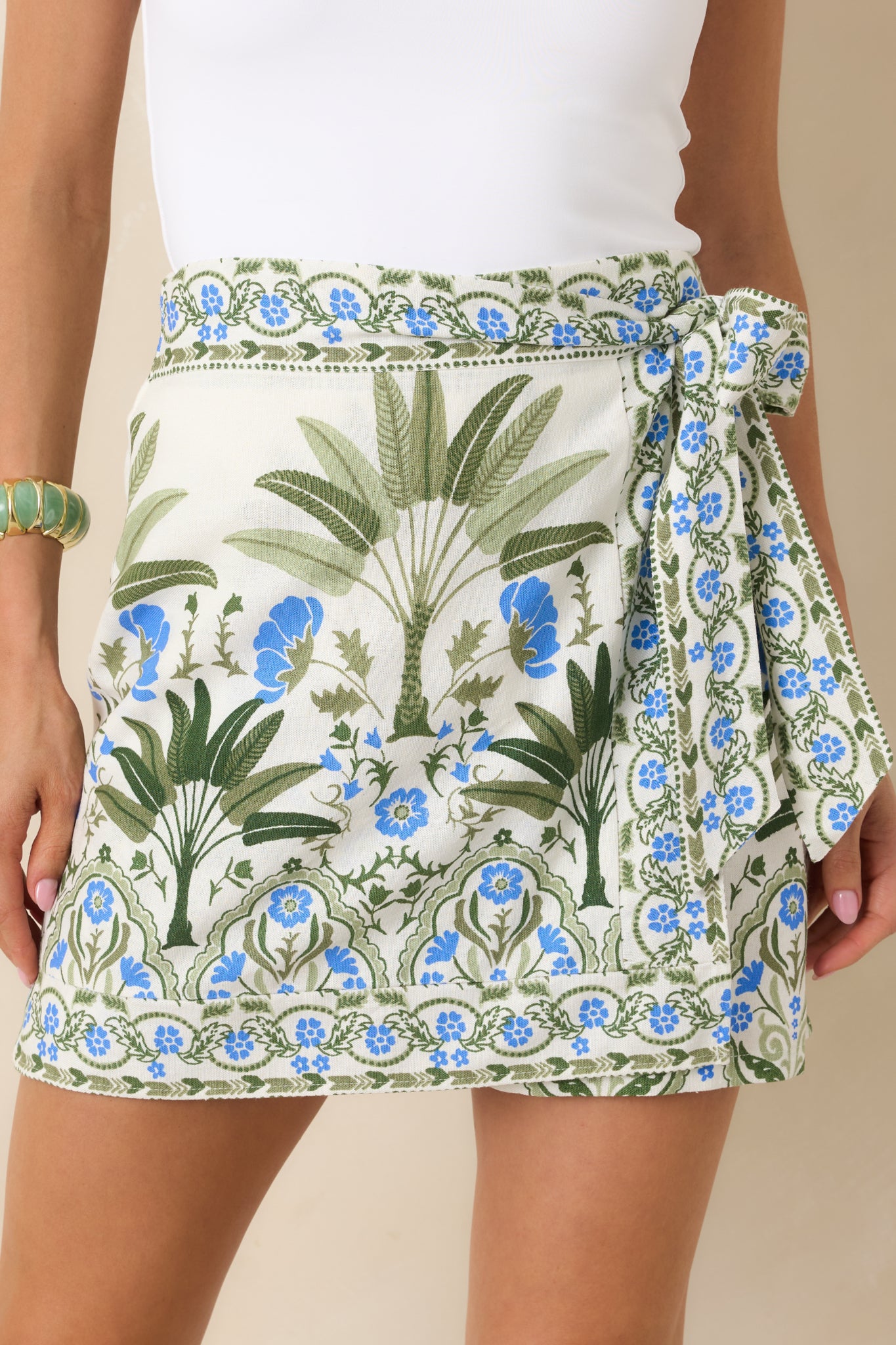 Close-cropped image showing the high-rise waistband and tailored fit of the ivory floral mini skort.