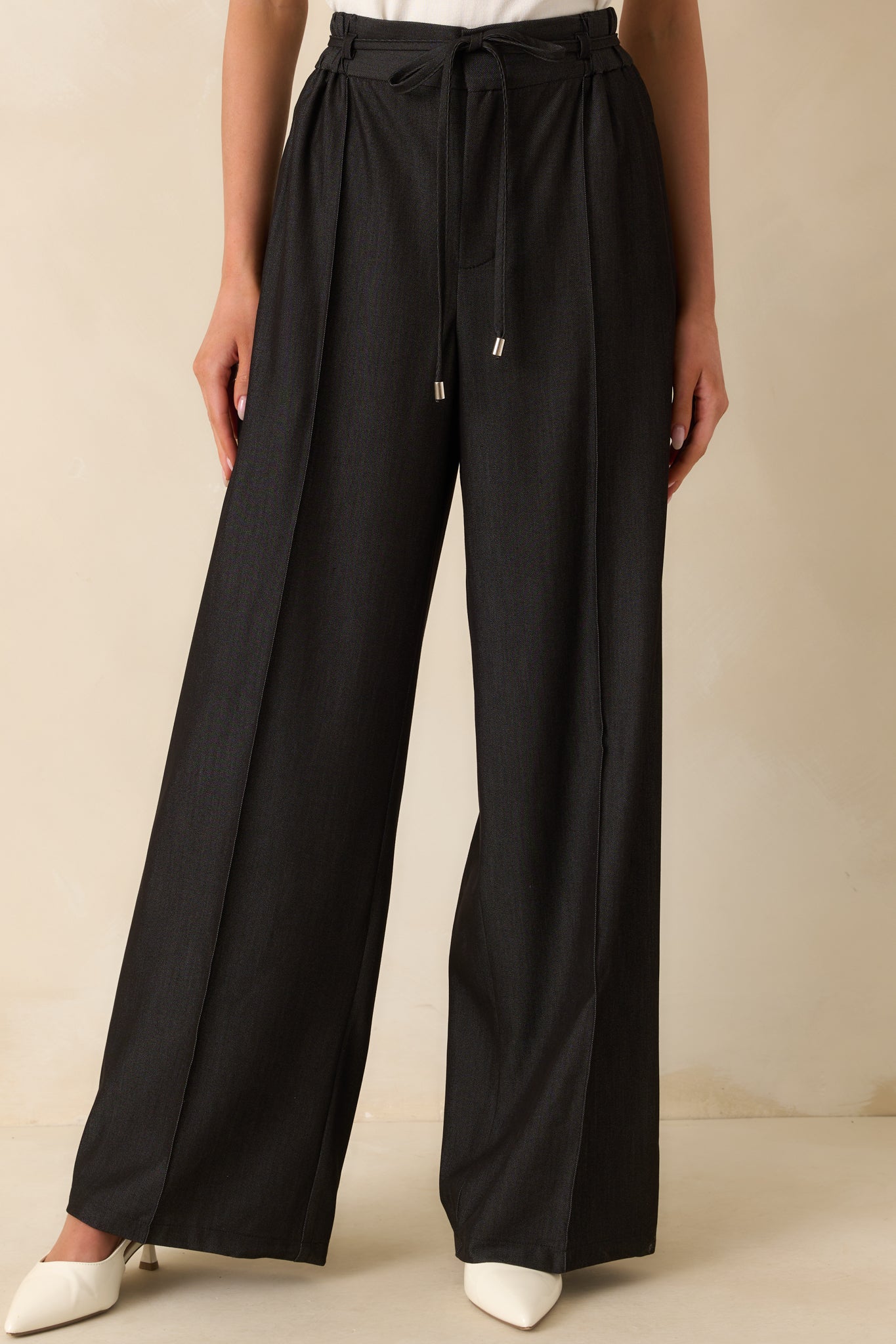 Cropped lower leg view emphasizing the clean lines and seam details down the front of the legs.