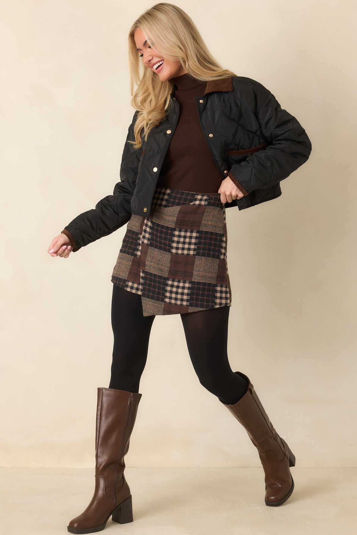 Cropped quilted jacket with a brown collar, black edge binding, and a row of front snap closures.